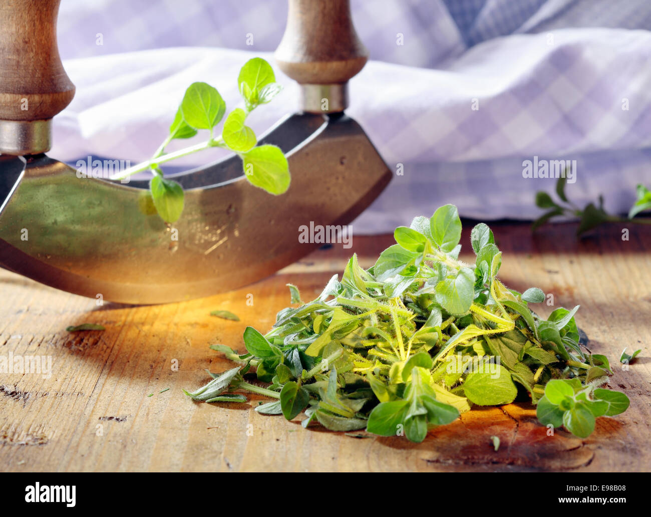 Chopping fresh marjoram with a curved rocker knife for use as an