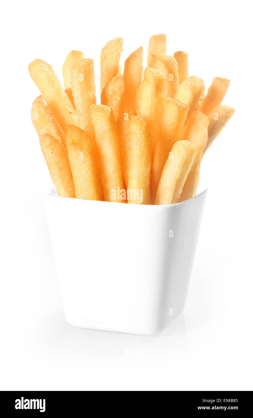 Crisp deep-fried golden potato chips, or French fries, standing upright in a plain white ceramic container over a white background Stock Photo