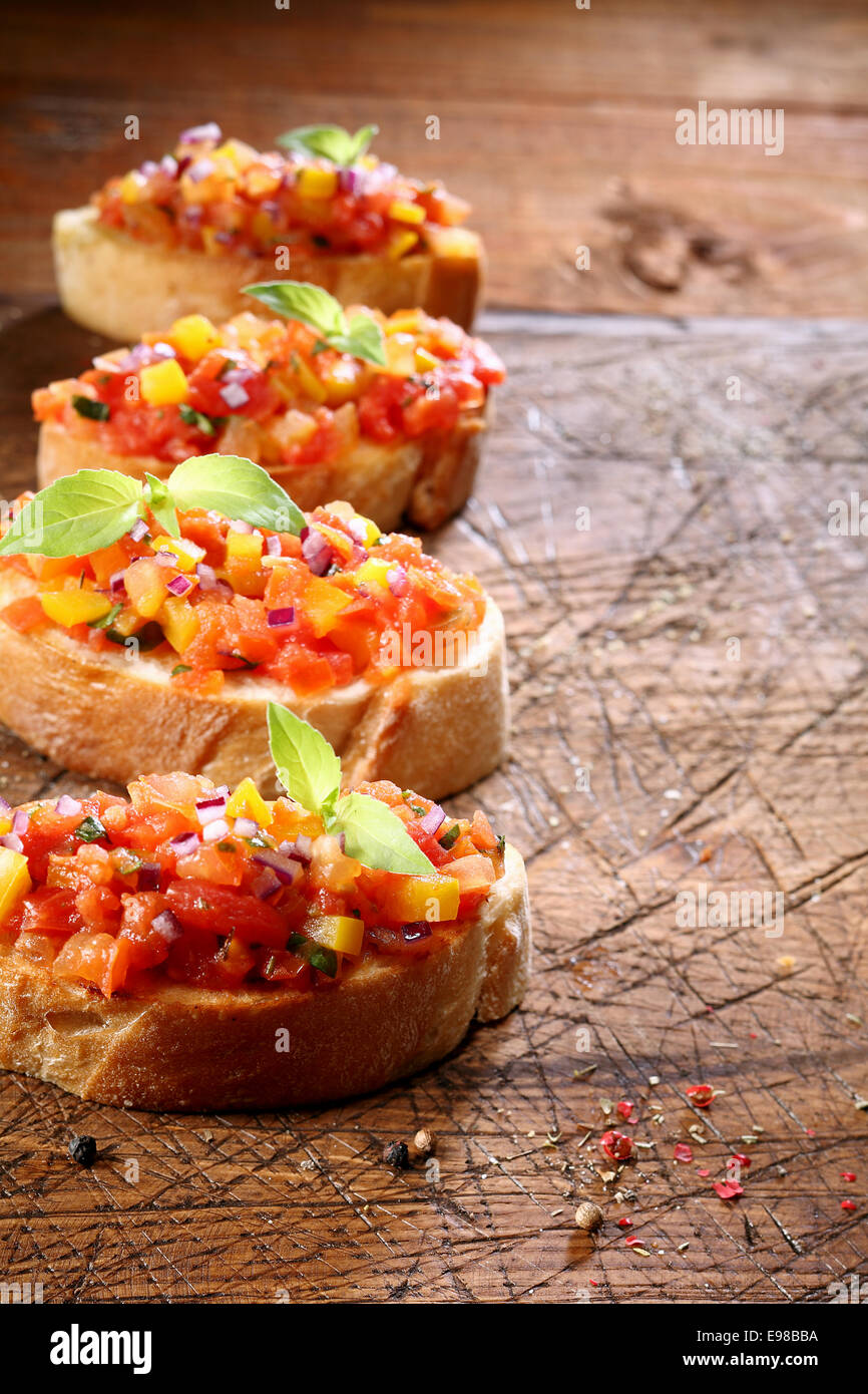 Row of delicious toasted crusty baguette with tomato bruschetta, an