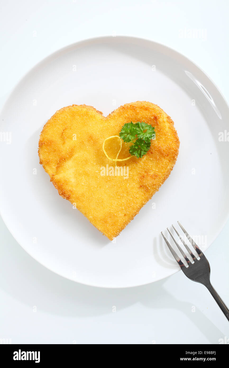 Overhead view of a crispy golden heart shaped escalope of veal pan fried in breadcrumbs