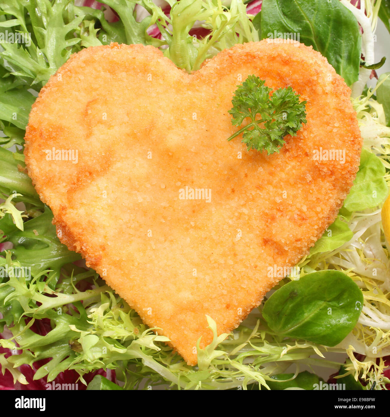 Romantic heart shaped fried golden schnitzel in breadcrumbs served on a