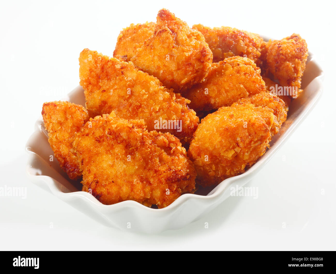 Golden crisp fried crumbed chicken nuggets served in a fluted dish as
