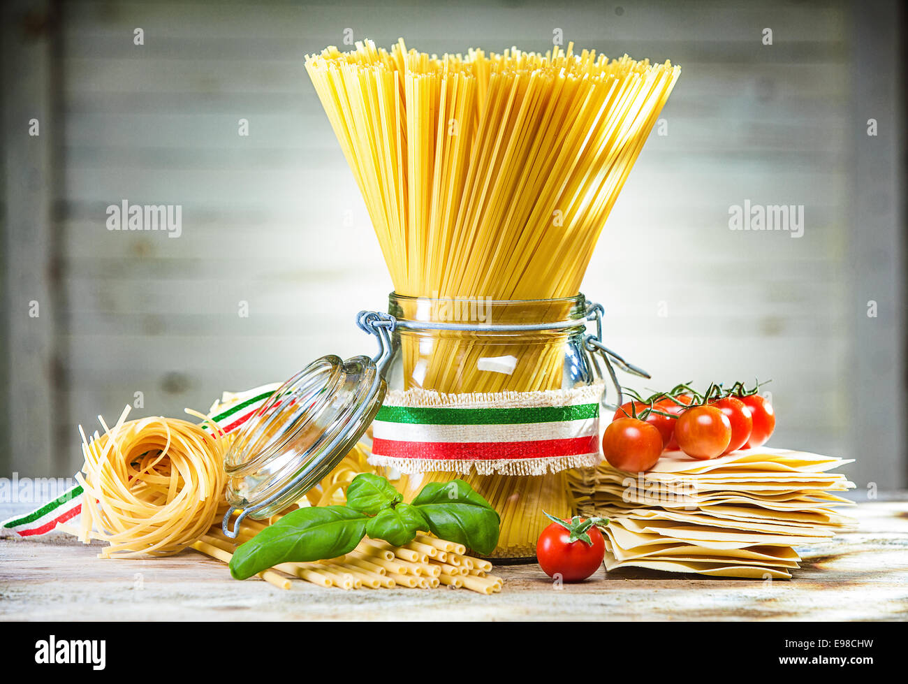 Bundle of uncooked dried Italian spaghetti tied with a ribbon in the colours of the national flag - red, white and green - with Stock Photo