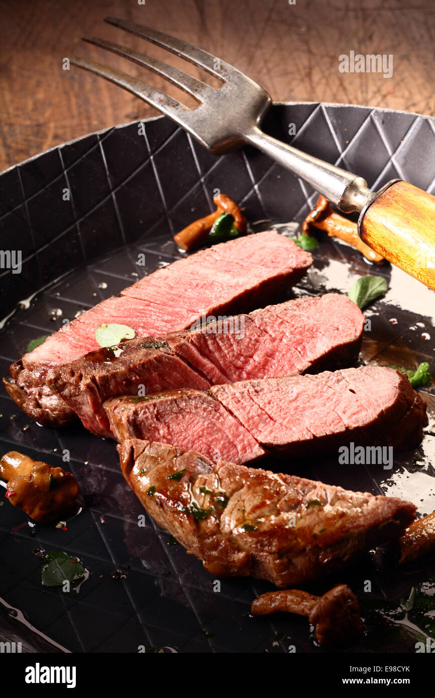 Pan roasted rare beef steak sliced through to expose the delicious pink