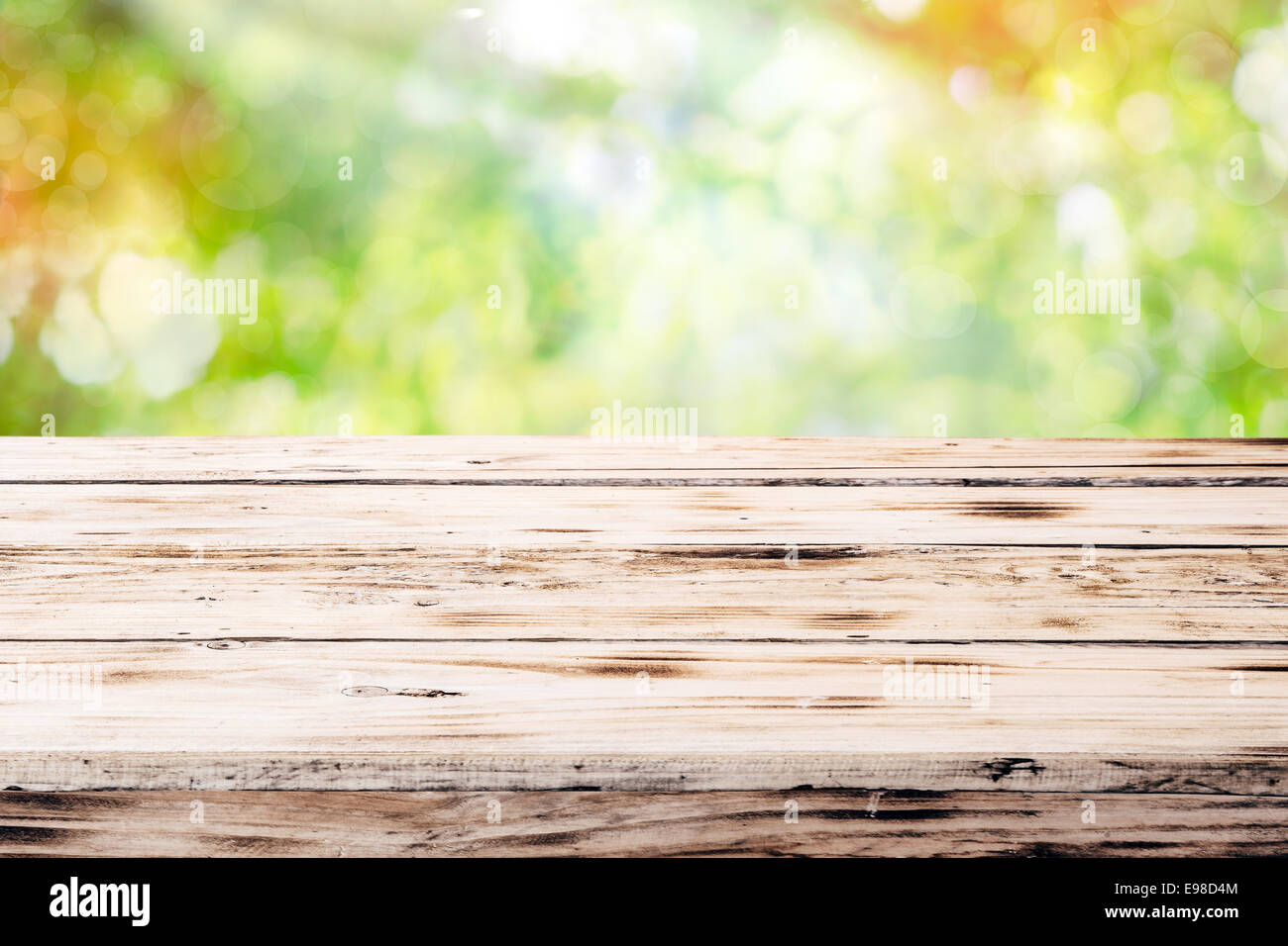 Old empty rustic grunge wooden table top against a blurred green ...