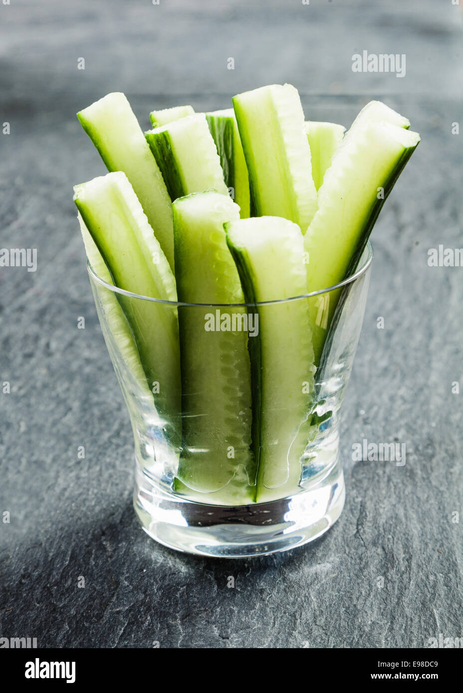 Delicious succulent cucumber crudties cut into thin strips or batons and served in a glass container on a buffet as appetizers to dip in a savory sauce Stock Photo