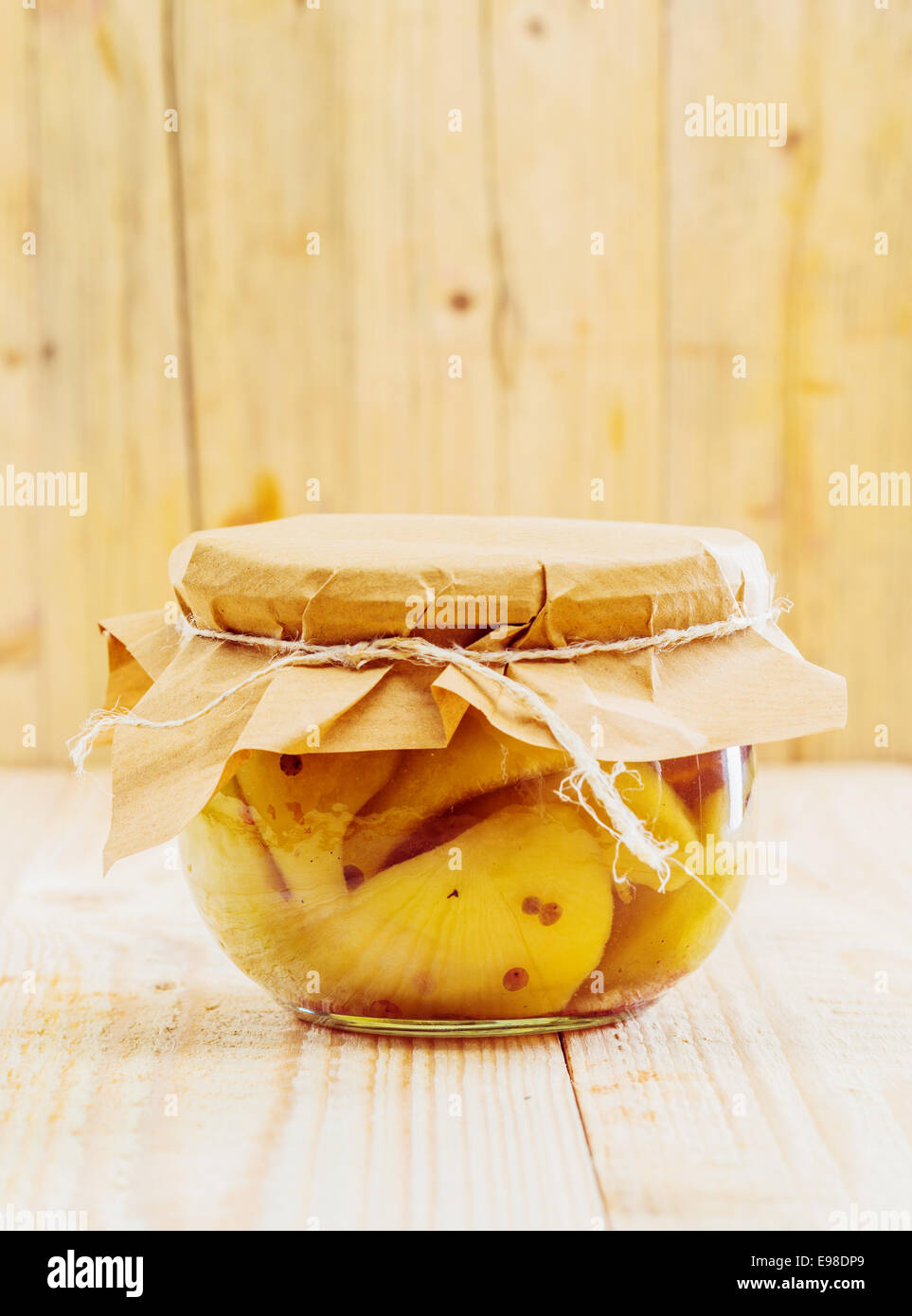 Speciality gourmet confection of preserved pears and vanilla tied off with a piece of rustic brown paper and string in a wooden Stock Photo