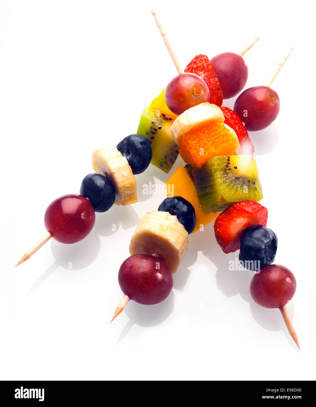 Vibrant fresh fruit kebabs for a healthy snack with assorted grapes, strawberries, blueberries, banana, kiwifruit and orange on Stock Photo
