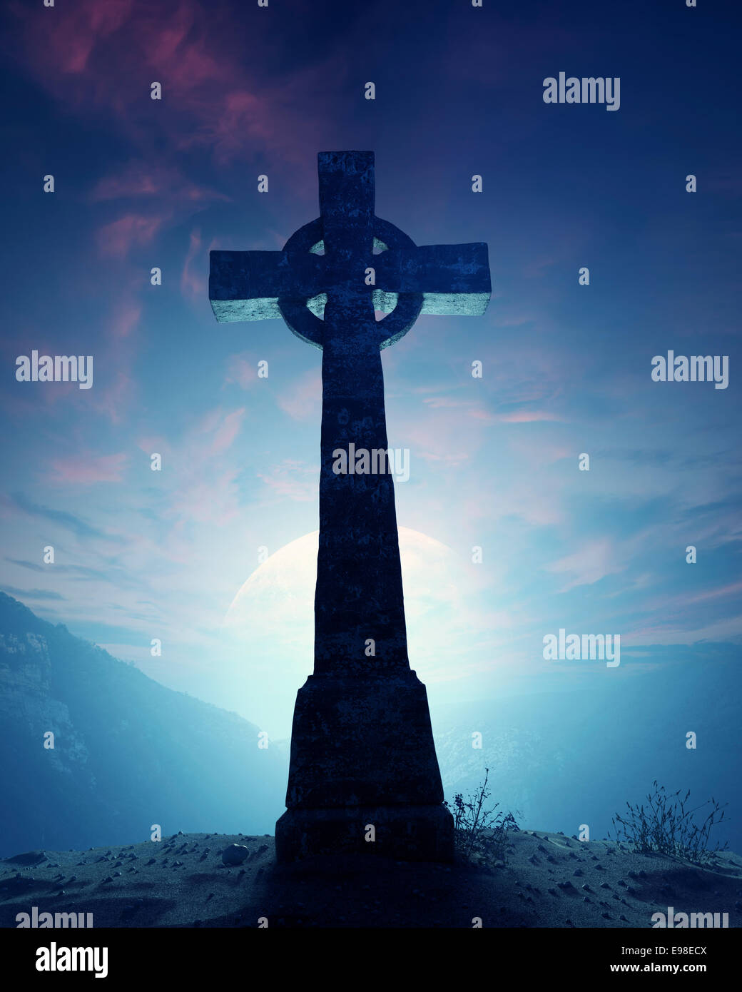 Celtic Cross with moon on crest of rocky mountain Stock Photo