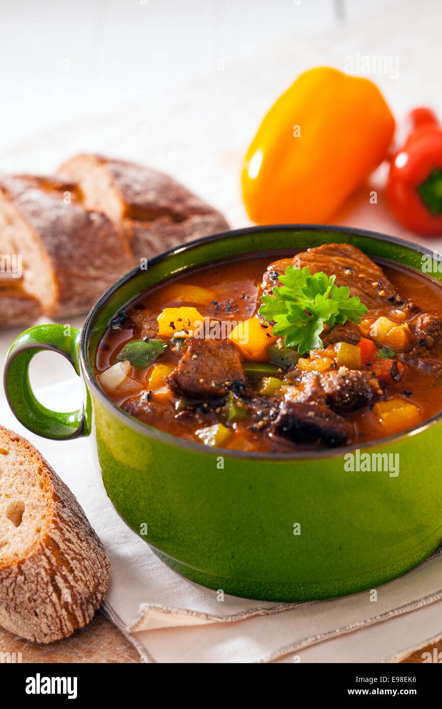 Nutritious winter casserole with meat and vegetables in a rich gravy served with slices of bread Stock Photo