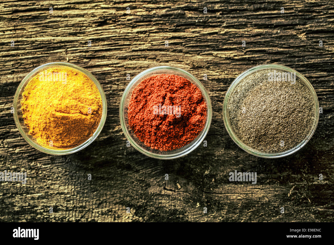 https://c8.alamy.com/comp/E98ENC/overhead-view-of-three-open-spice-containers-with-colourful-curry-E98ENC.jpg