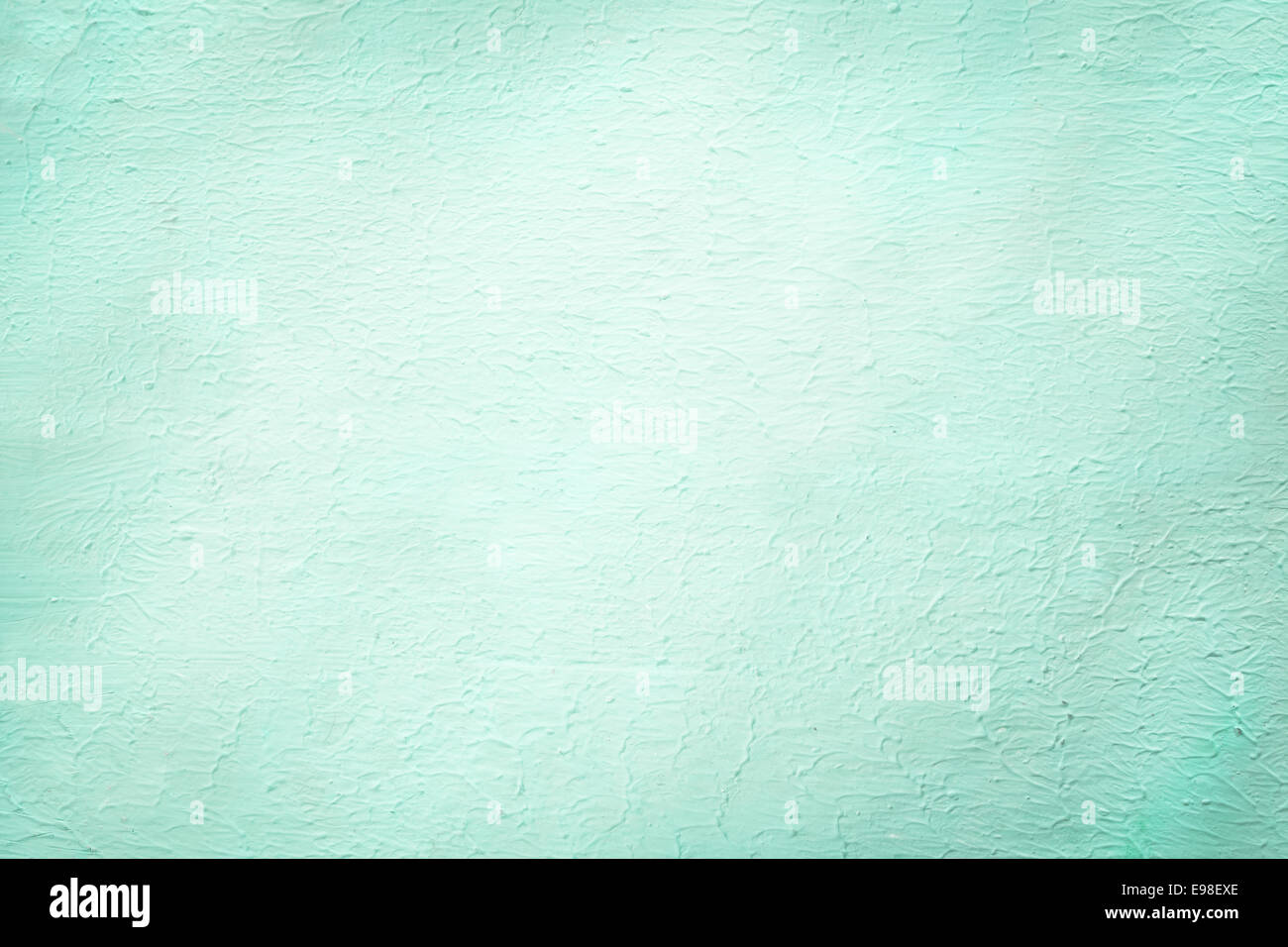 Aquamarine rough plaster surface finish background texture in a 2014 fashion color with a faint vignette and central copyspace Stock Photo