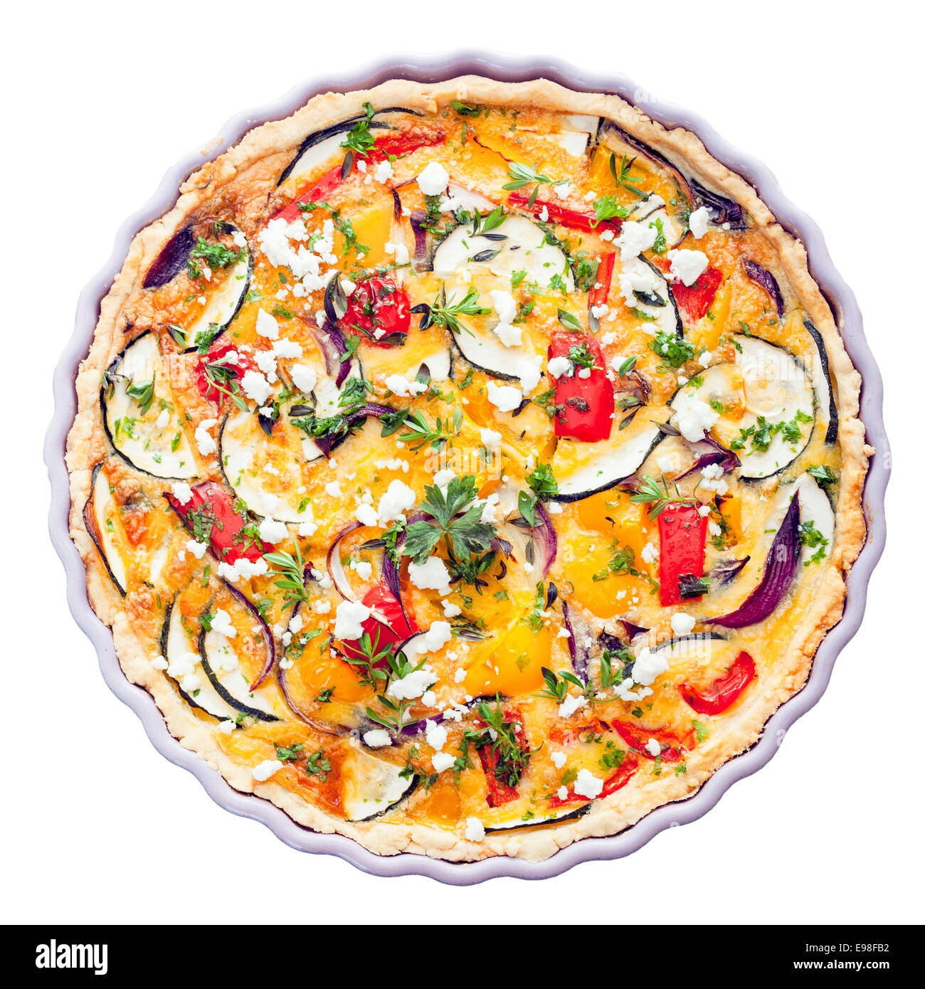 Overhead view of a delicious savory tart with clipping path in a decorative fluted pie dish with eggplant, cheese, egg, herbs and peppers for a tasty vegetarian meal Stock Photo