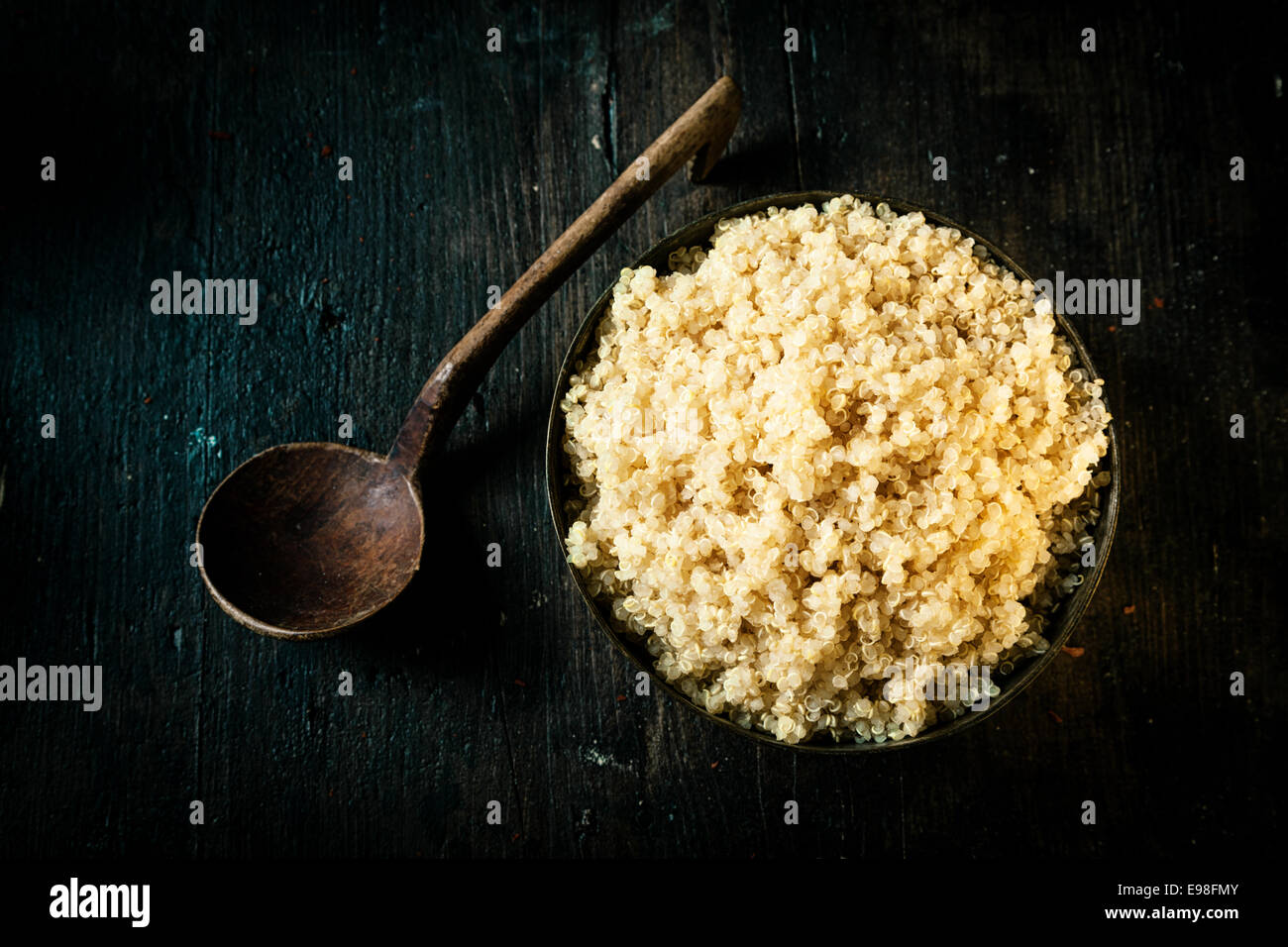 Overhead view of a bowl of delicious healthy quinoa made from the seeds of the goosefoot plant and classed as a superfood for its high protein and nutritional value on a dark background Stock Photo