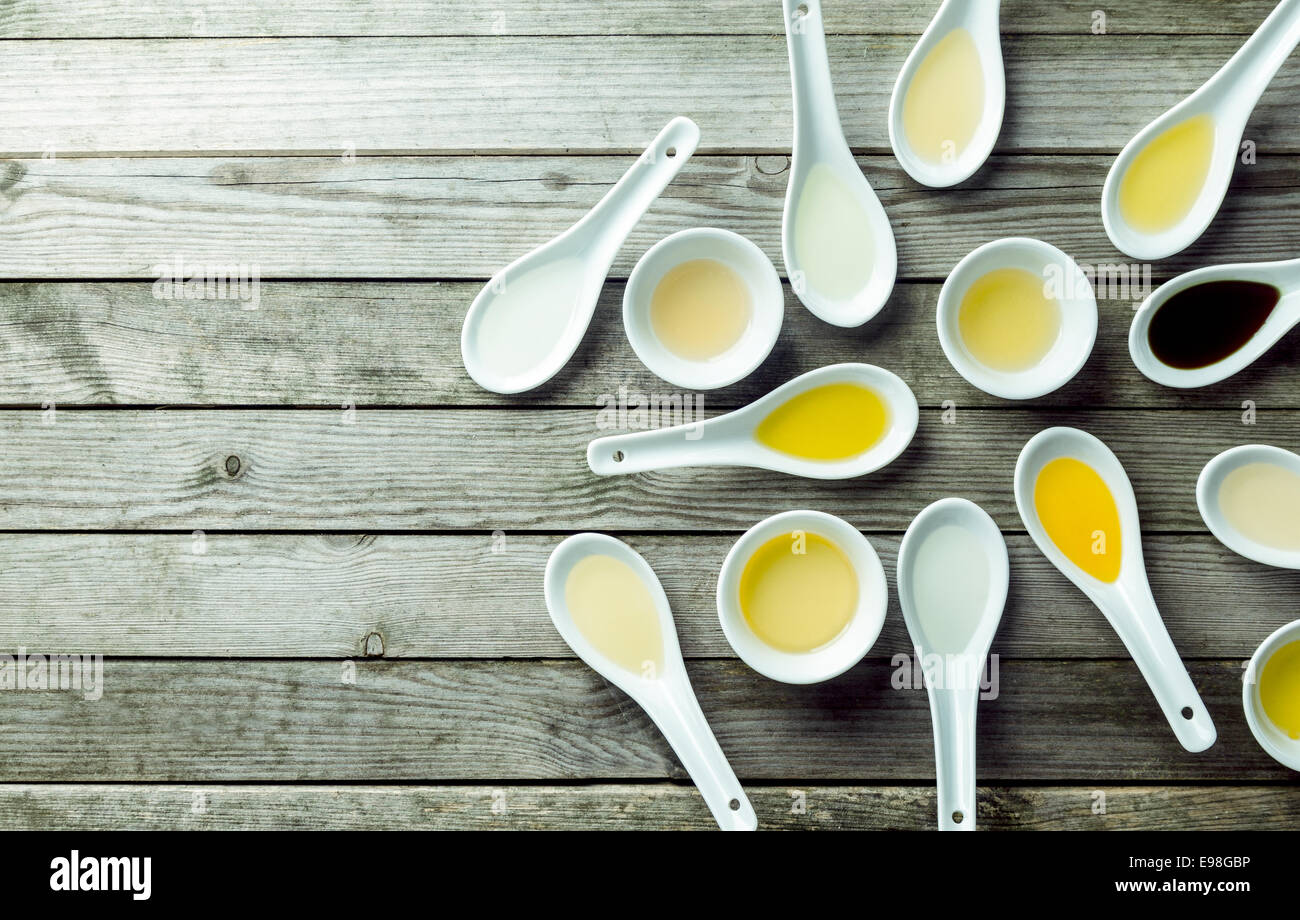 Topview of several soup spoons and sauce dishes filled with different colored oils Stock Photo