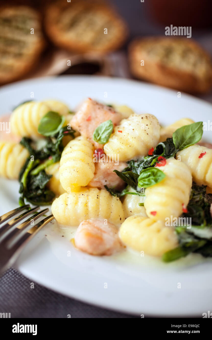 Salmon, Gnocchi pasta and fresh basil served on an oval platter for a