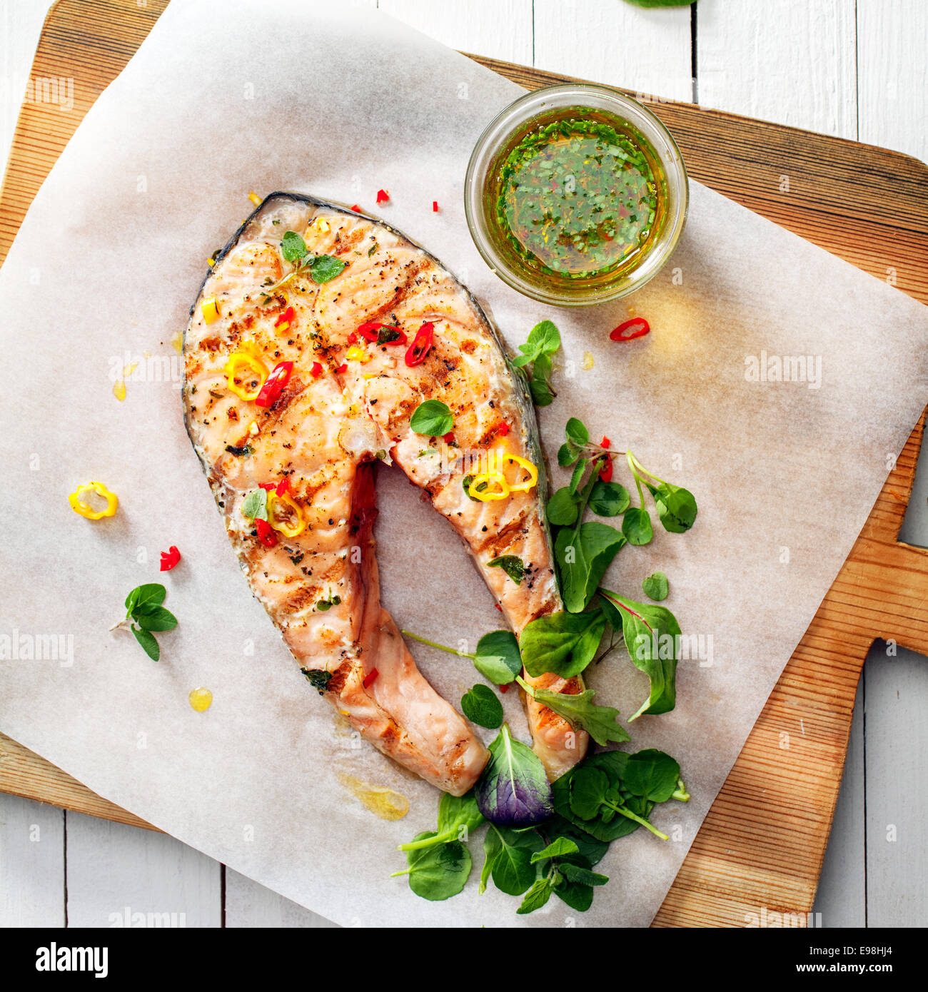 Preparing delicious grilled salmon steak with fresh basil leaves