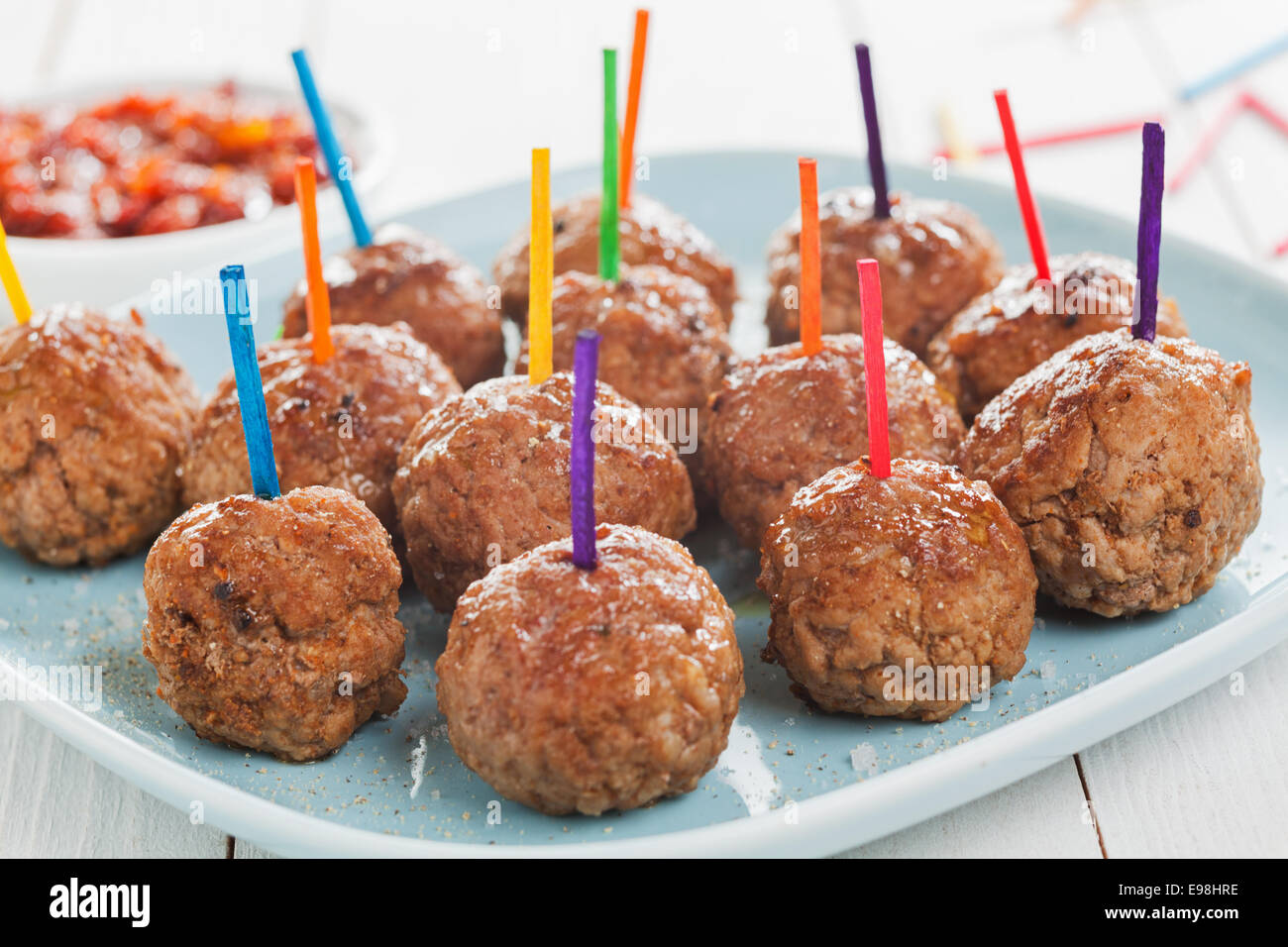 Tray of savory spicy meatballs for appetizers arranged on a tray on a buffet with colorful