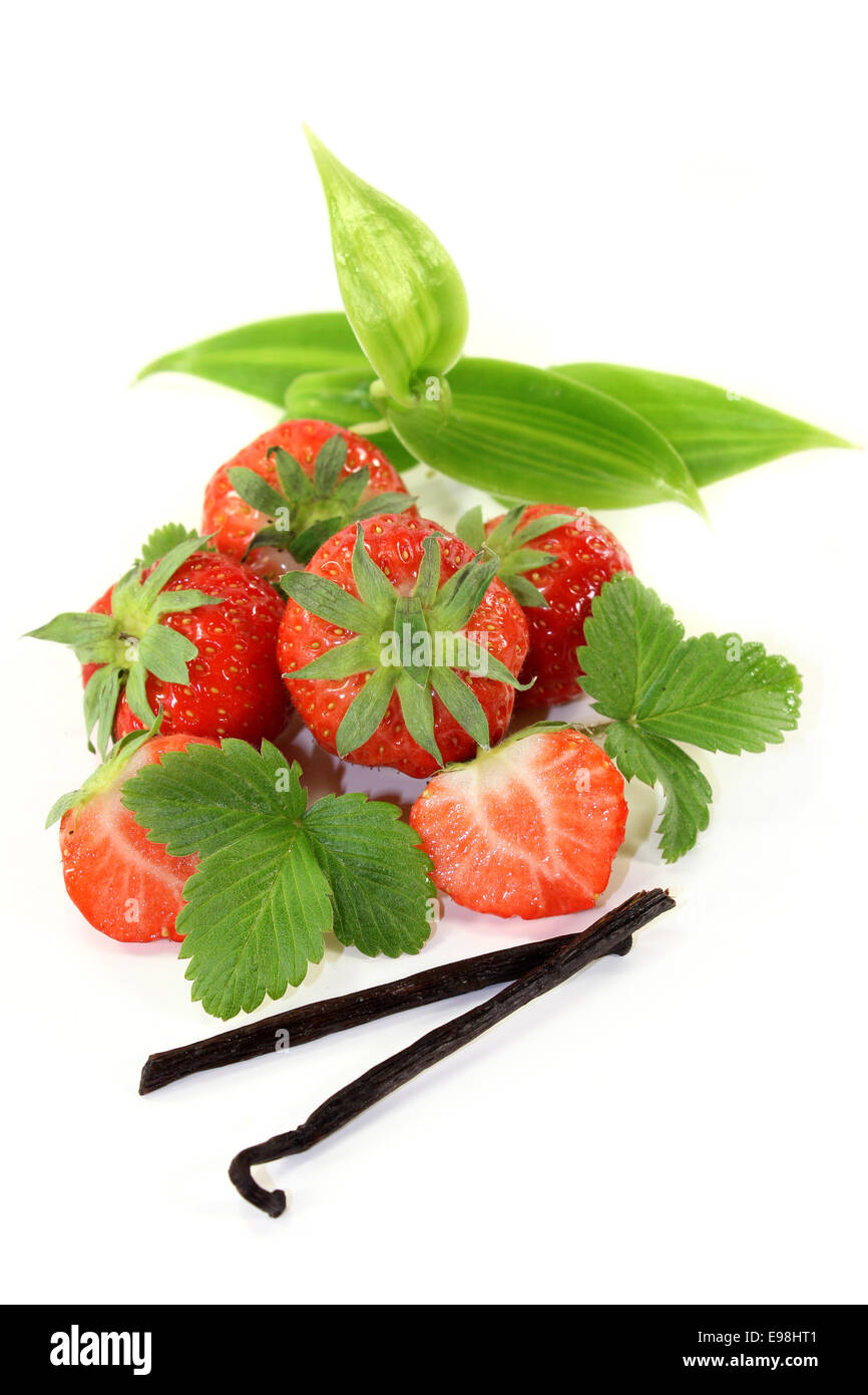 a vanilla bean with vanilla leaves and fresh strawberries Stock Photo