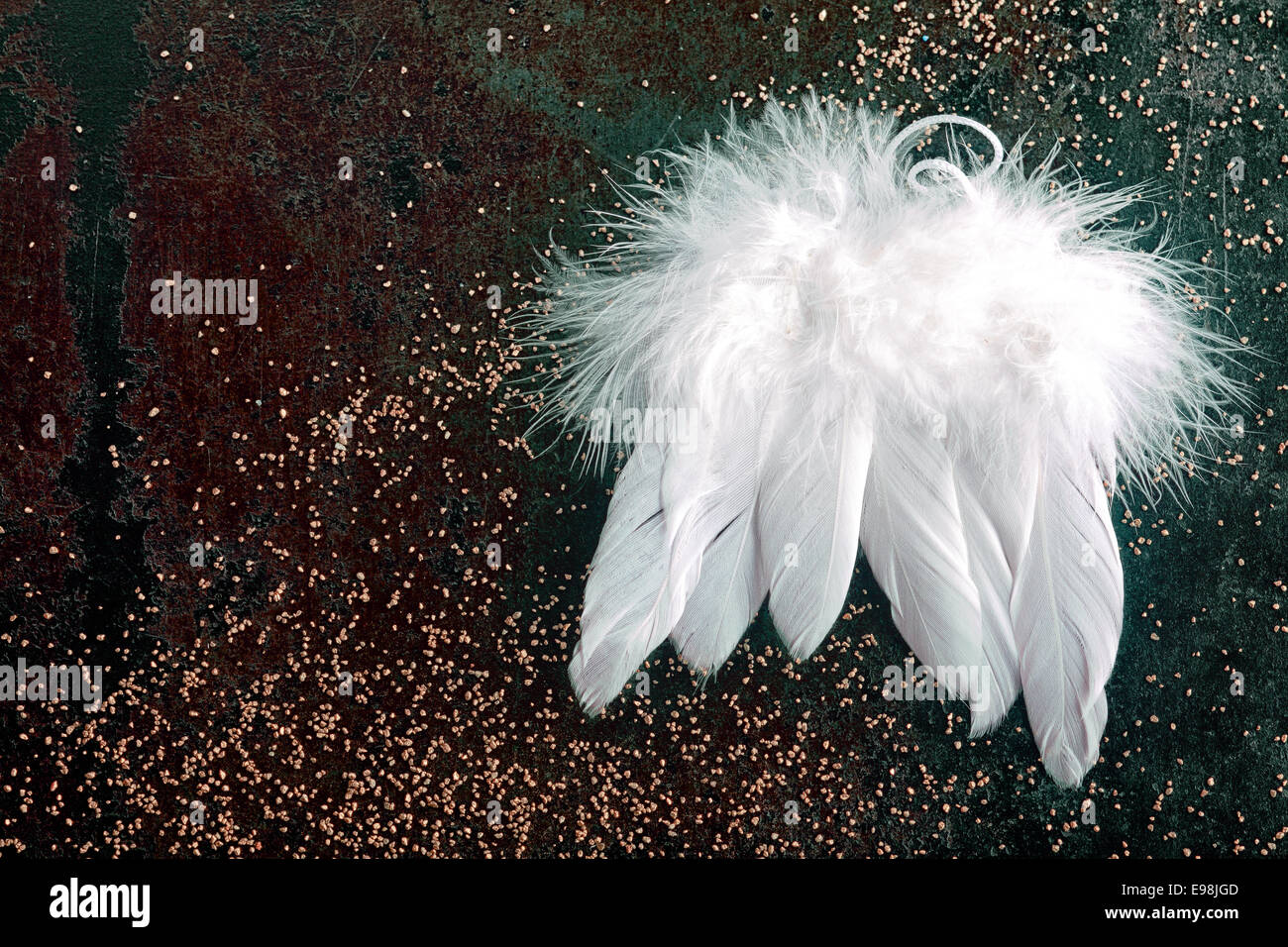 Soft white Christmas angel wings made from birds feathers on a dark background with glitter for a seasonal Xmas background with Stock Photo