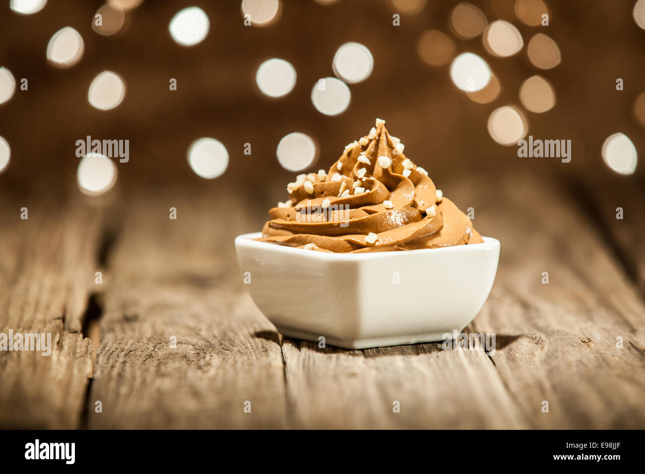 Macro Mouth Watering Brown Frozen Yogurt on Bowl Placed on Wooden Table Stock Photo