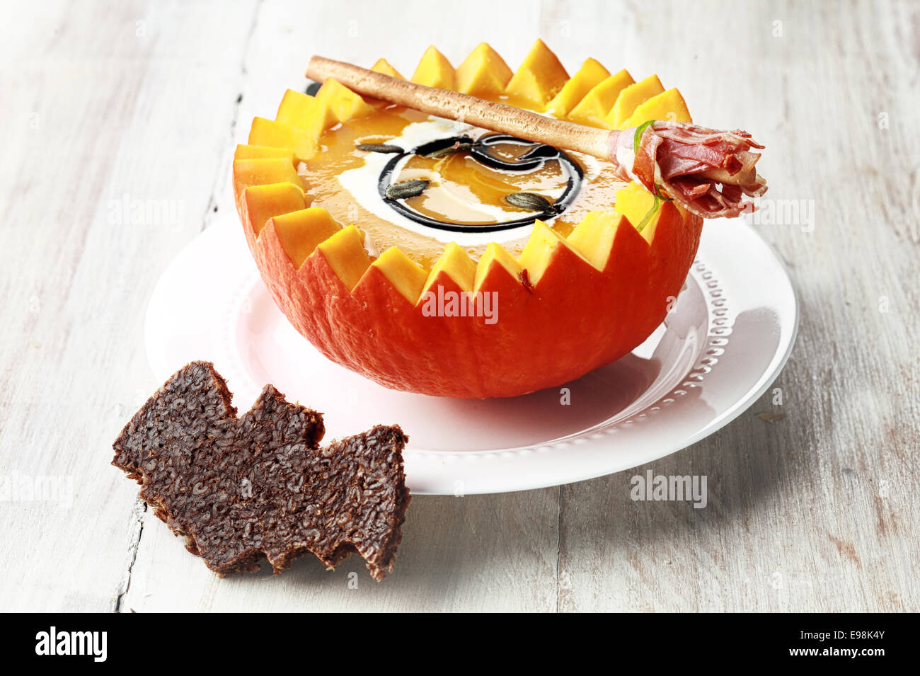 Pumpkin Soup with Bat Crouton Toast Served in Half a Pumpkin with Broomstick Breadstick Stock Photo