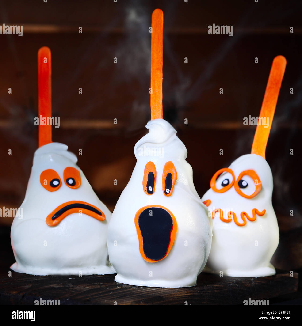 Three homemade creative Halloween candy pears or white chocolate ghosts on a stick Stock Photo