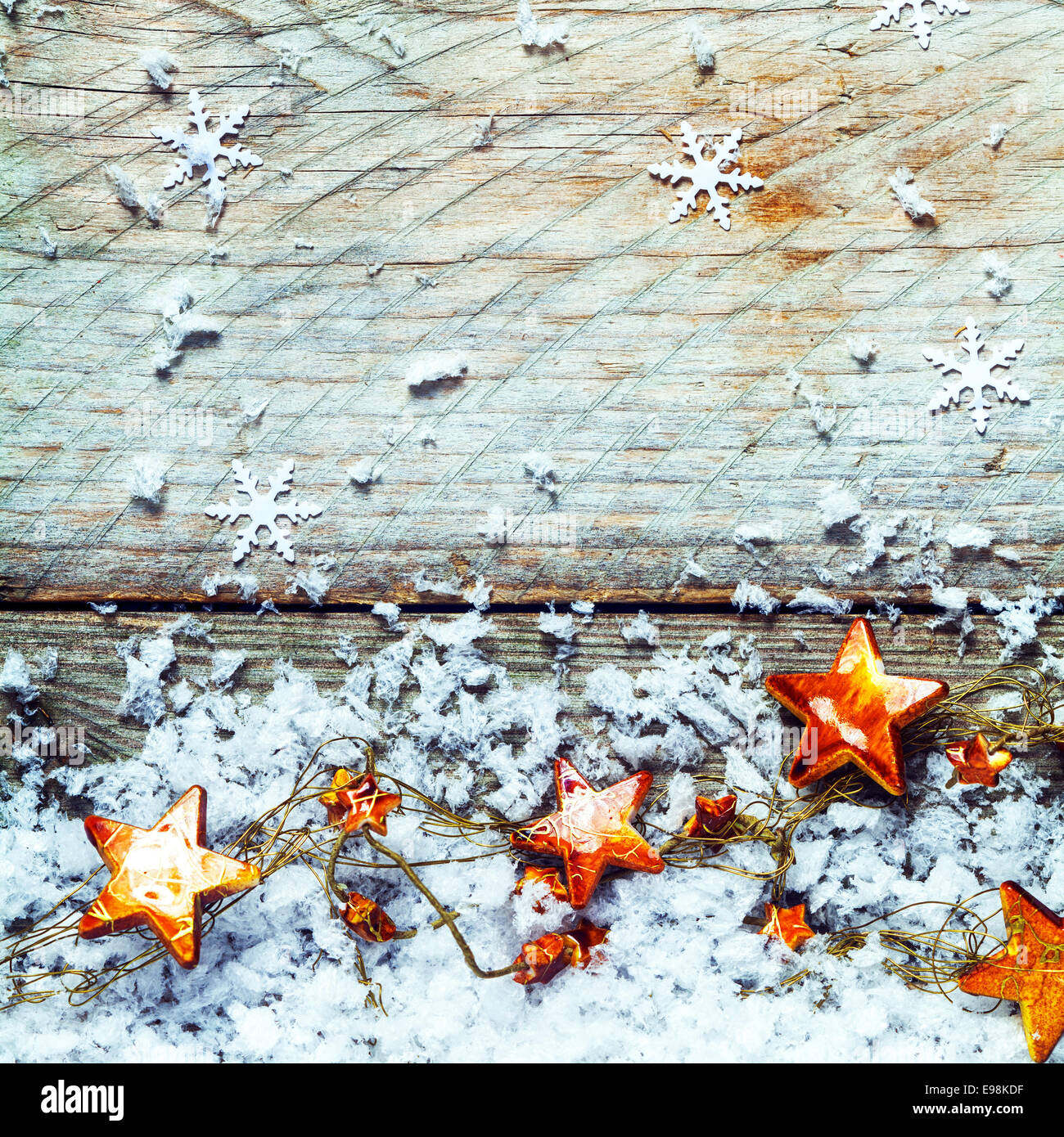 Golden stars with snow and falling snowflake decorations in a rustic ...