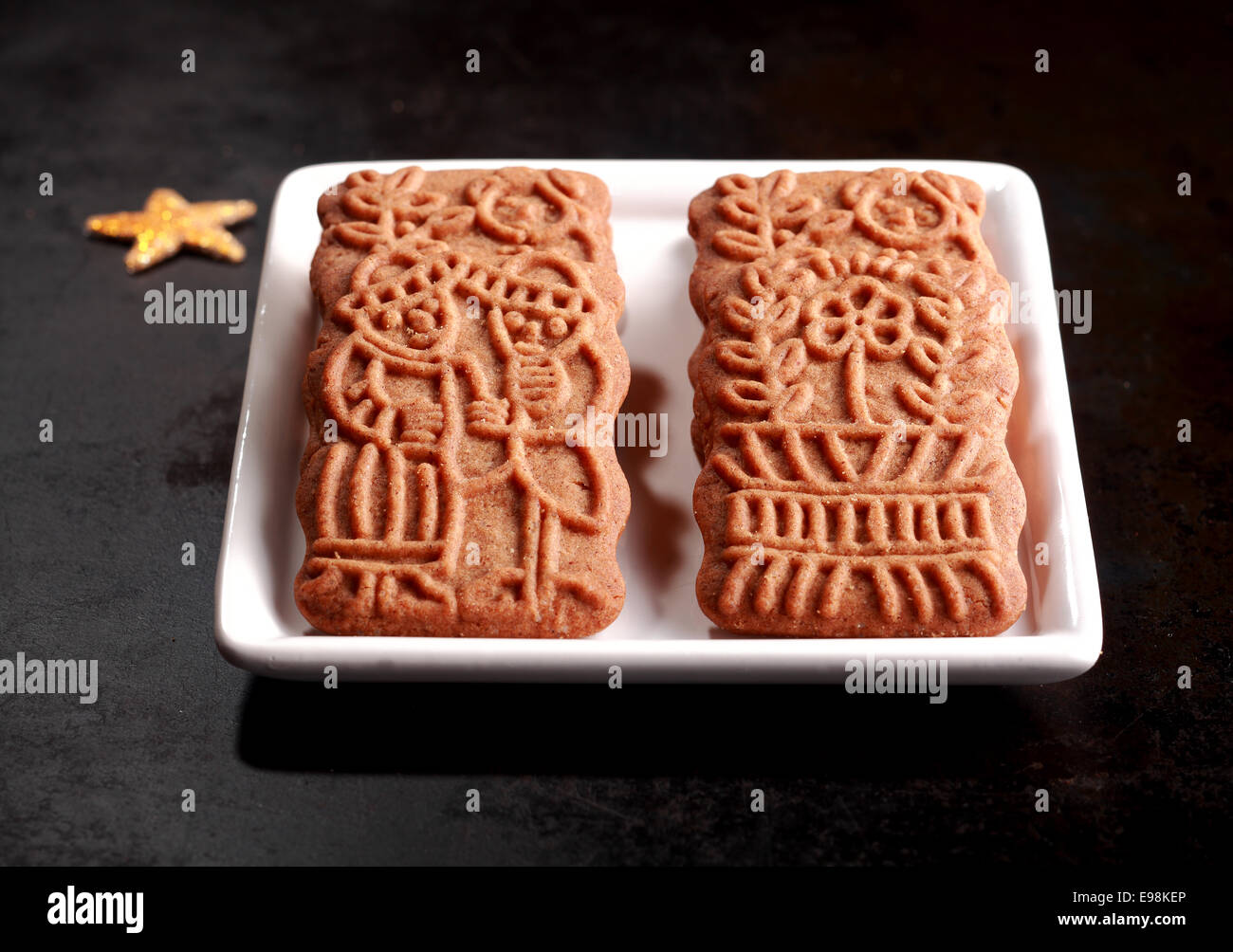 Two traditional spicy crisp Dutch speculoos biscuits, a speciality baked for the feast of St Nicholas and now consumed worldwide for Christmas Stock Photo
