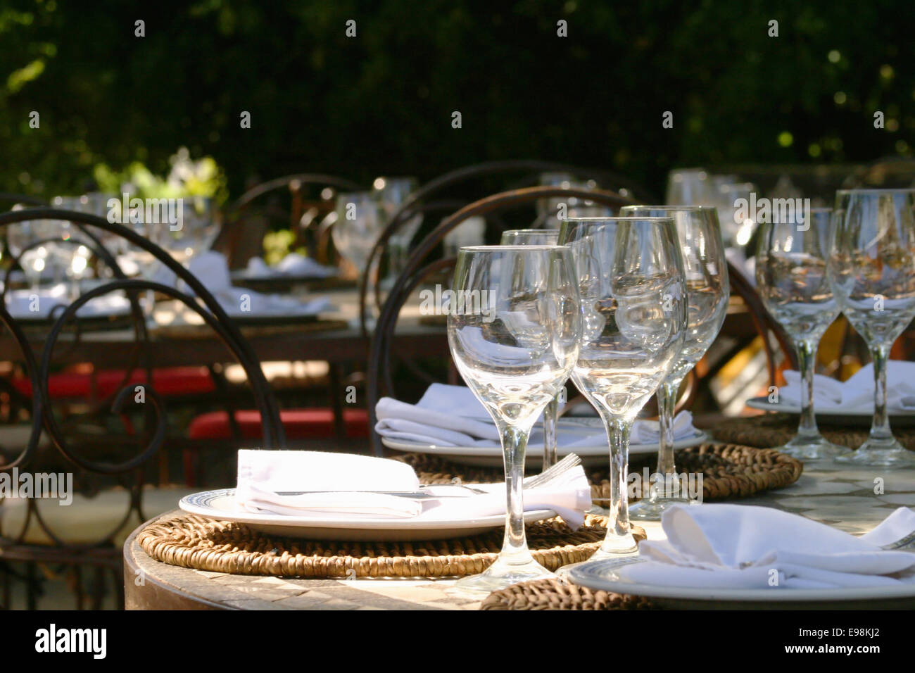 Banquet table in South afrika with glasses and napkins under a big tree Stock Photo