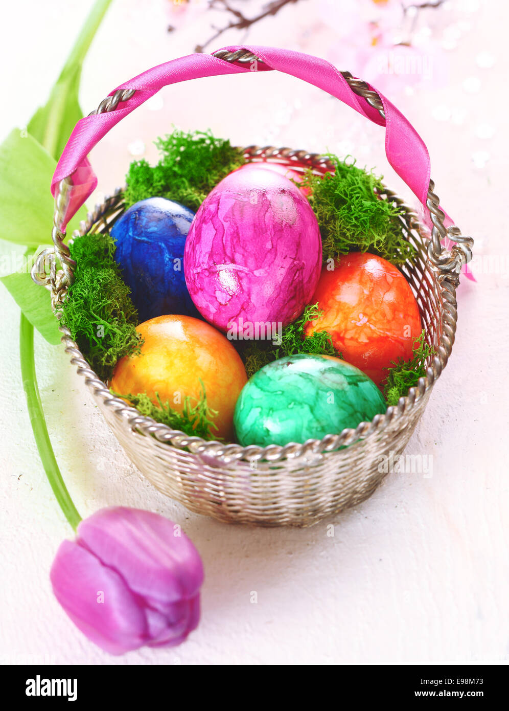 A basket full of colourful dyed marbled Easter eggs with a pretty pink ...