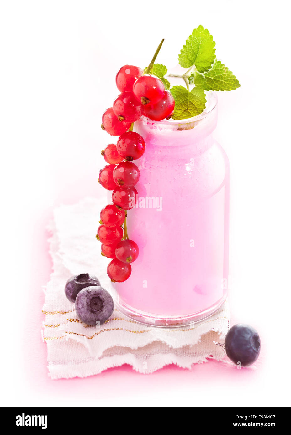 Healthy berry smoothie in a glass jar with delicious ripe red currants hanging over the side Stock Photo