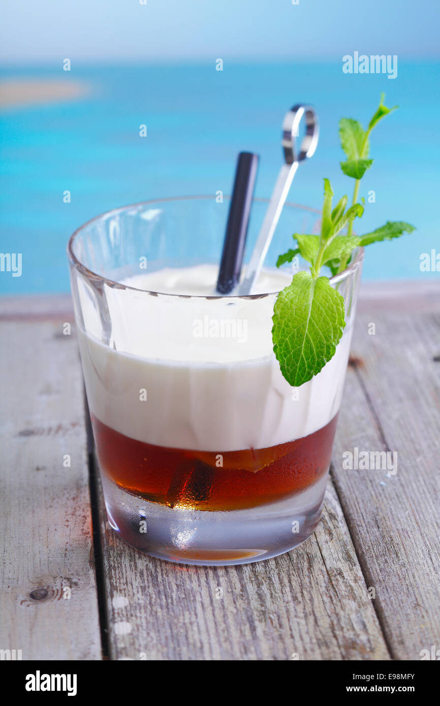 White Russian Coffee Cocktail with ice cubes and cream topping standing