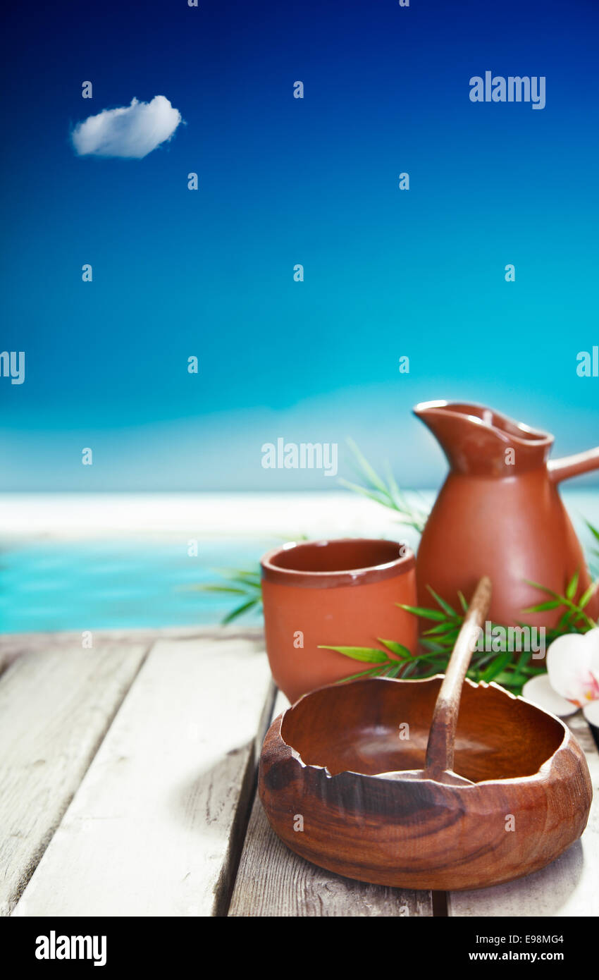 Earthenware mug and jug and small wooden bowl represent the simple cultural luxuries of traveling in tropical islands where natural local handicraft remain important Stock Photo