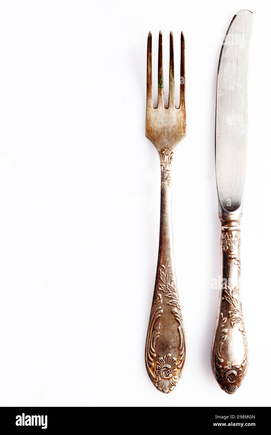 Silver cutlery setting comprising a knife anf fork on white with empty