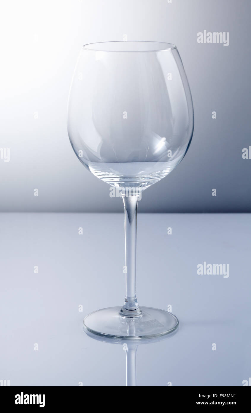 Empty wine glass with reflexion and a blue background Stock Photo