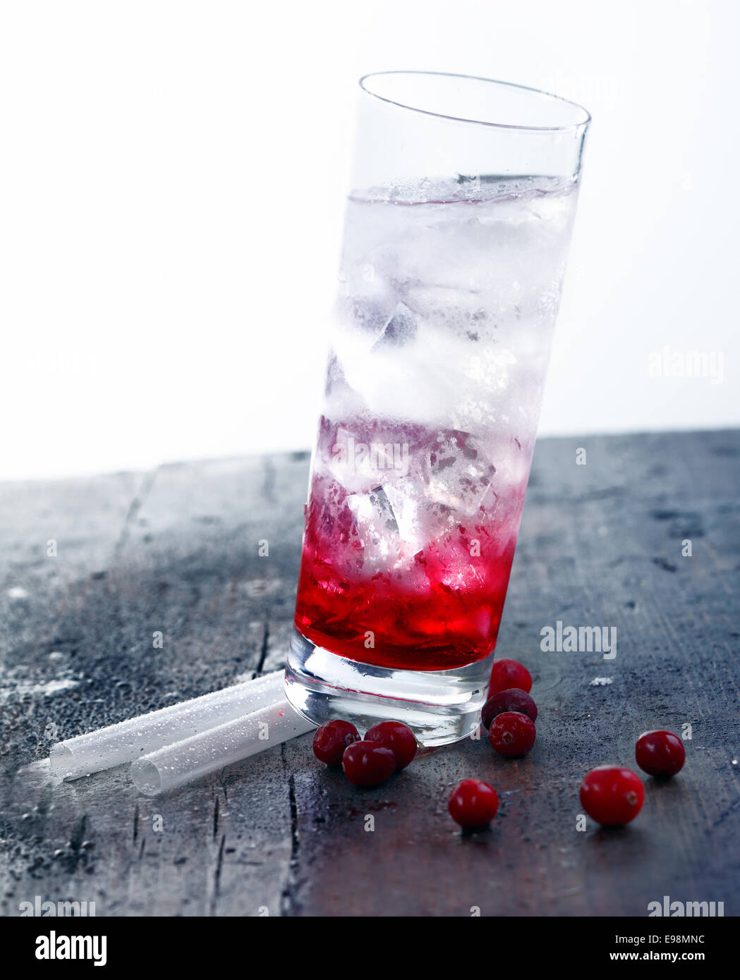 Cocktail Drink with grenadine standing on straws on a wooden vintage bar. Stock Photo