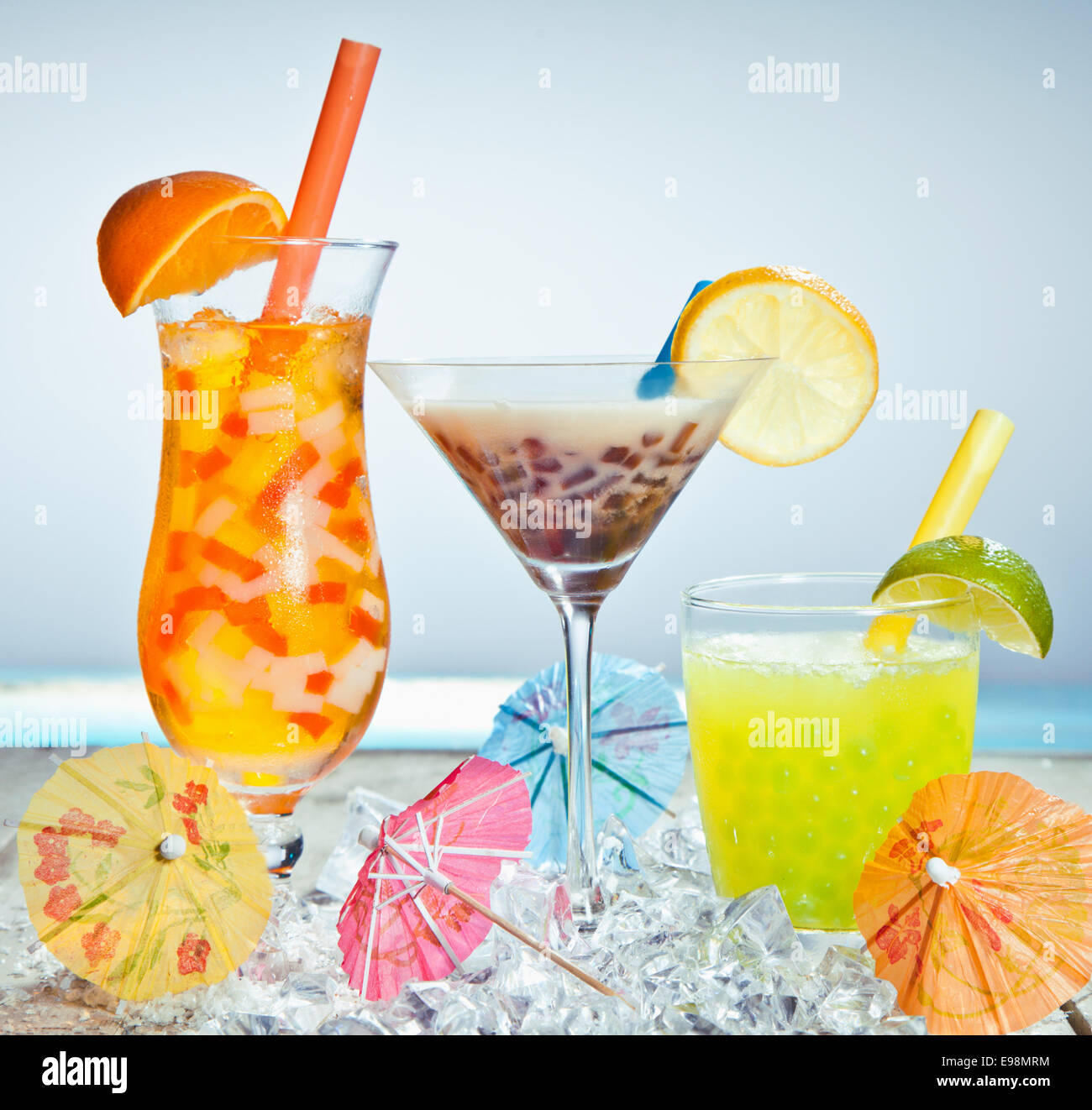 Three different boba tea cocktails with mango, orange, coffee and lime flavored. With paper umbrellas. Stock Photo