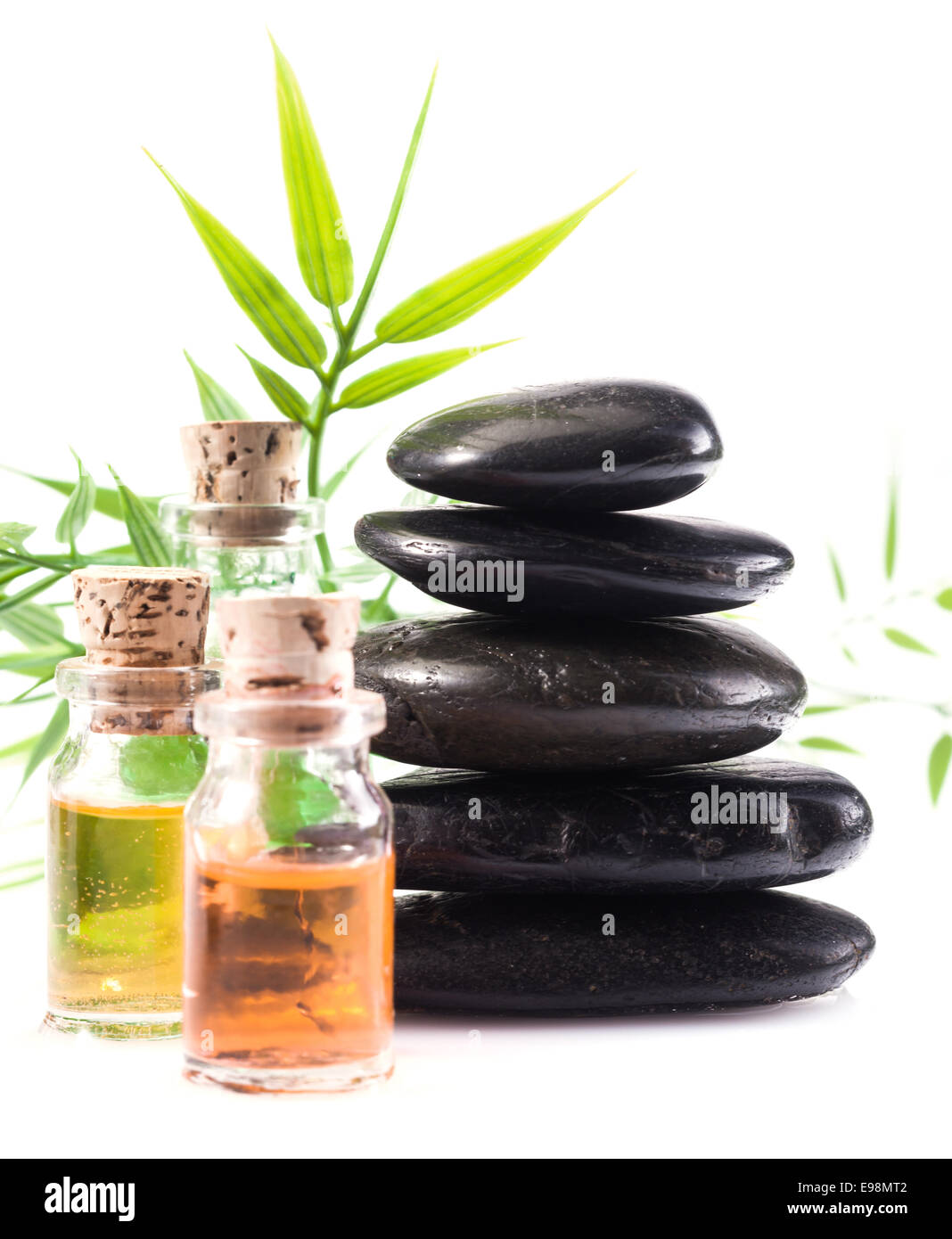Massage oils and basalt stones necessary for a hot rock treatment in a spa setting Stock Photo