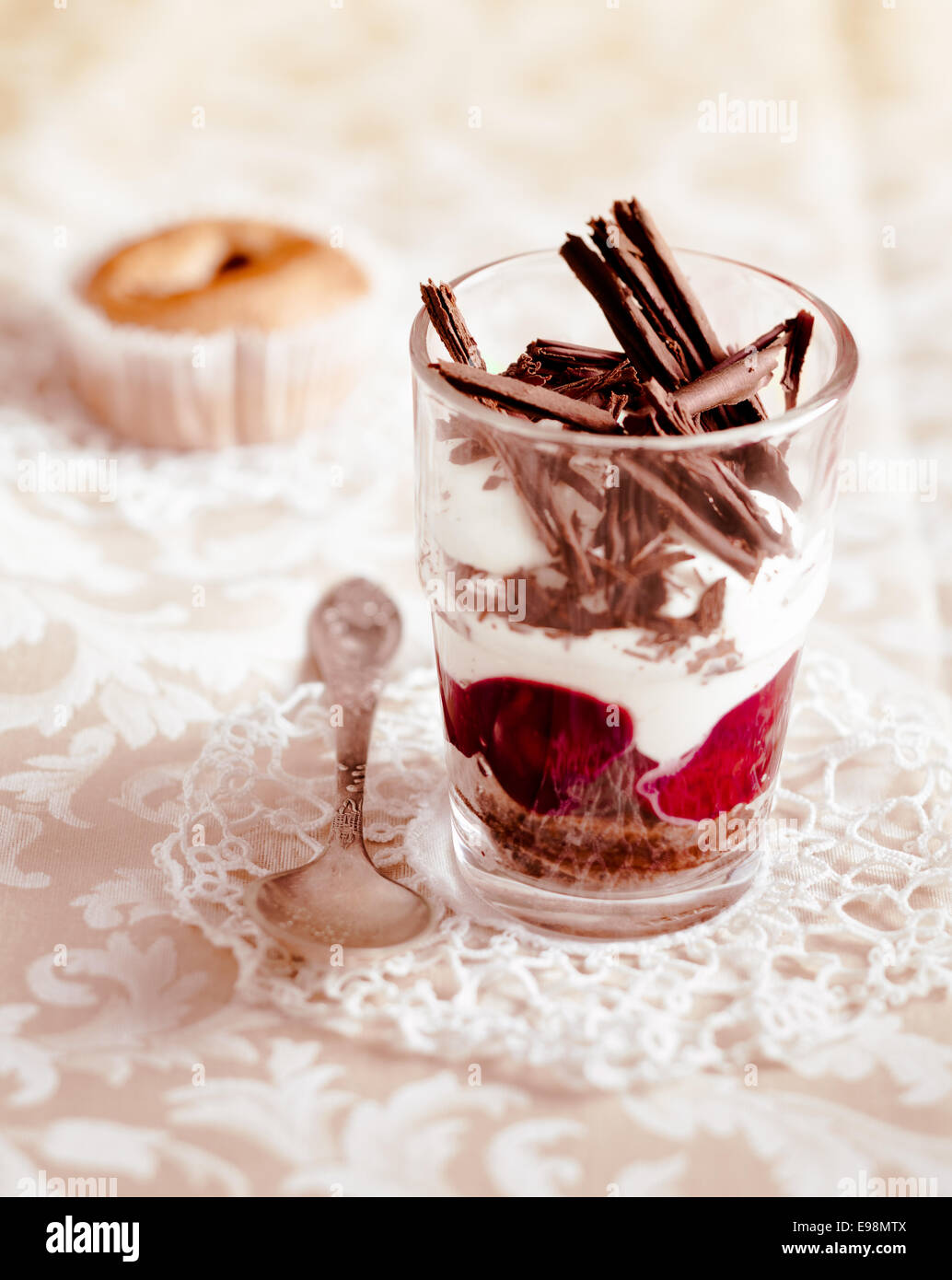 Gourmet fruit and cream parfait topped with chocolate shavings and served in a clear glass on a decorative doily Stock Photo