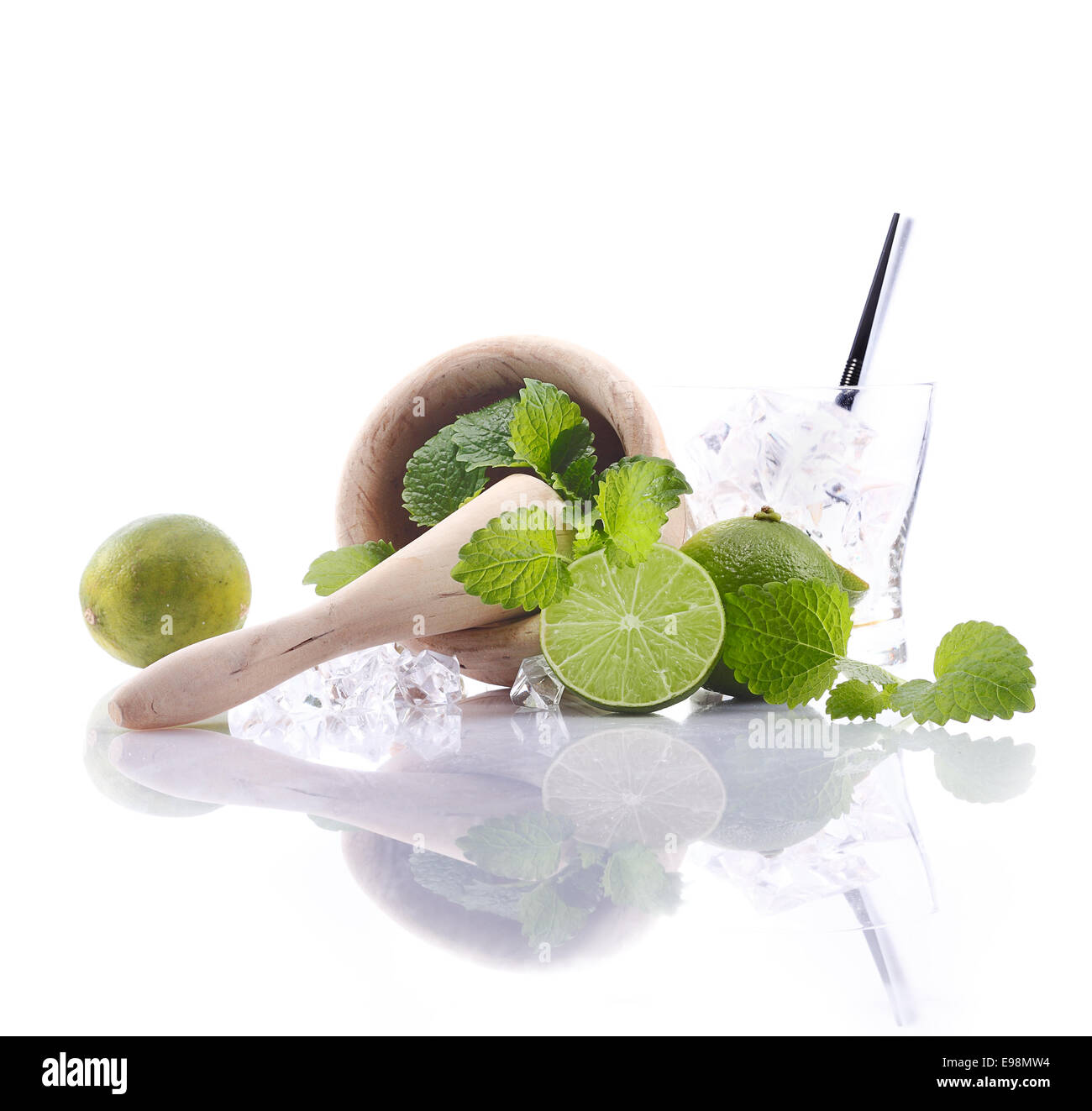 Caipirinha Ingredients with mortar and pestle and fresh lime. Aside an empty glass with ice cubes. For Drinkable Concepts Stock Photo
