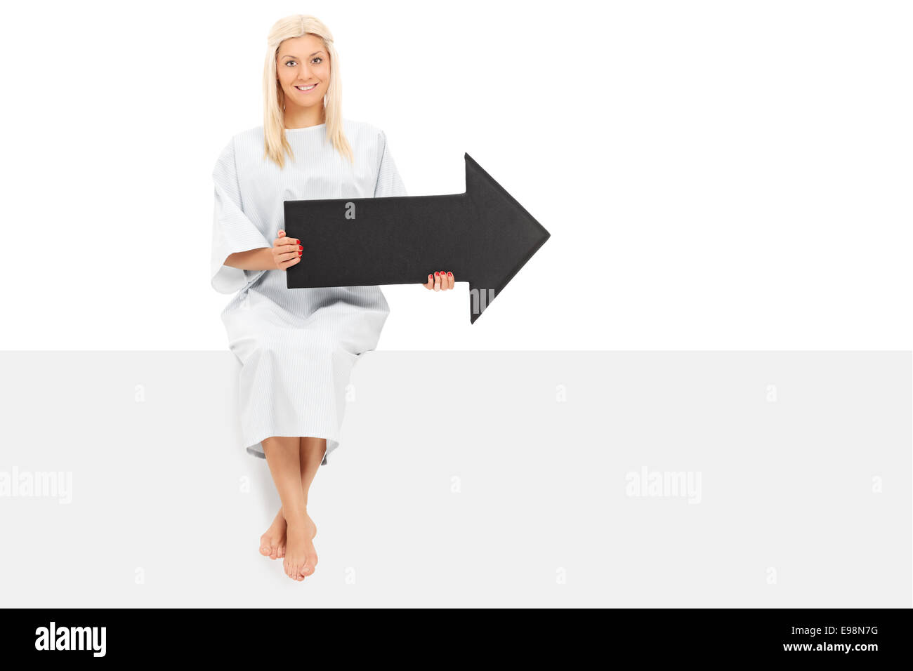 Female patient holding an arrow seated on a panel isolated on white ...