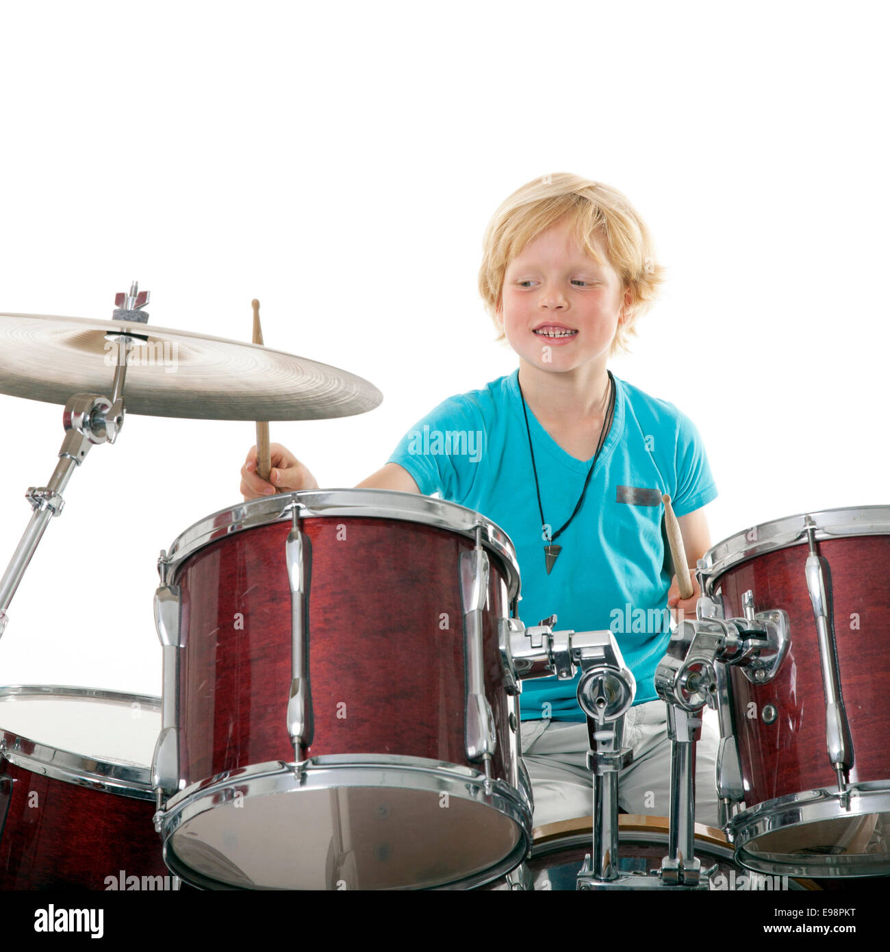 young boy playing drums against white background Stock Photo