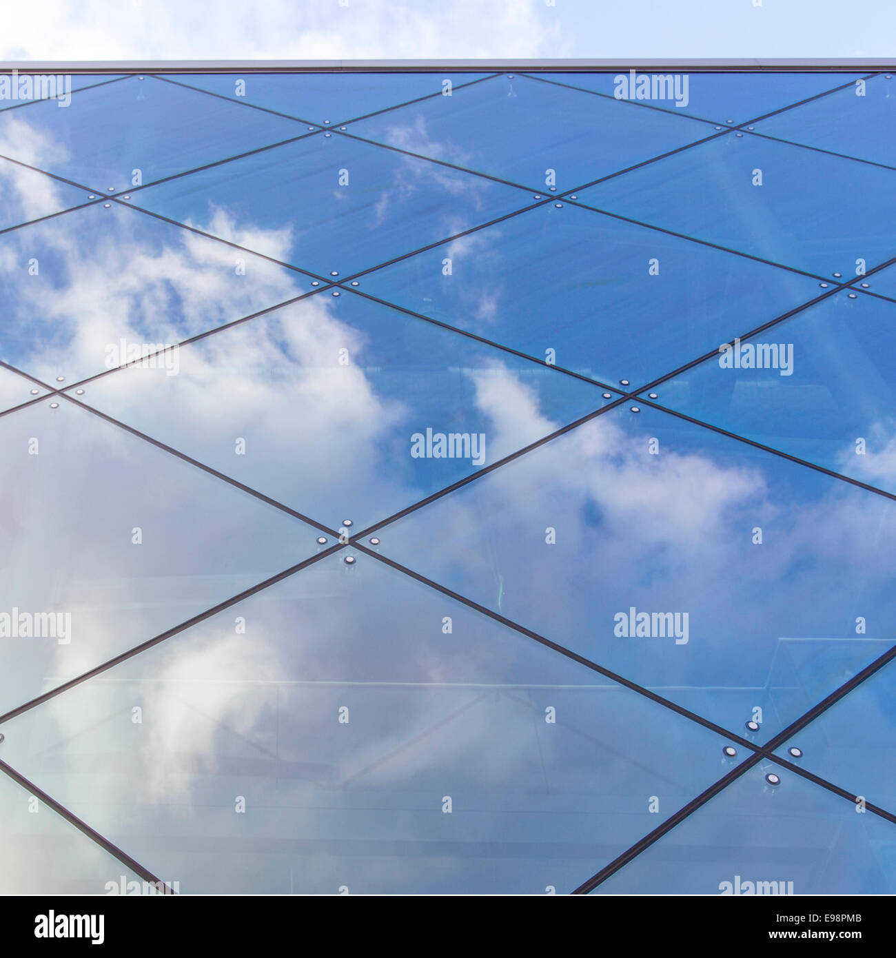 reflexions of clouds and blue sky in glass facade of modern building ...