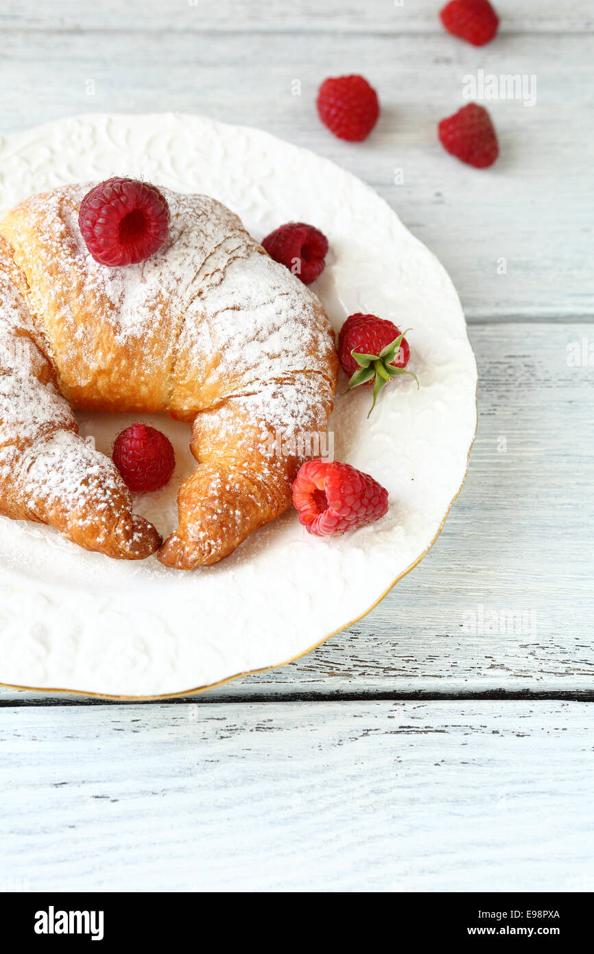 Sweet croissant with raspberry, on plate Stock Photo