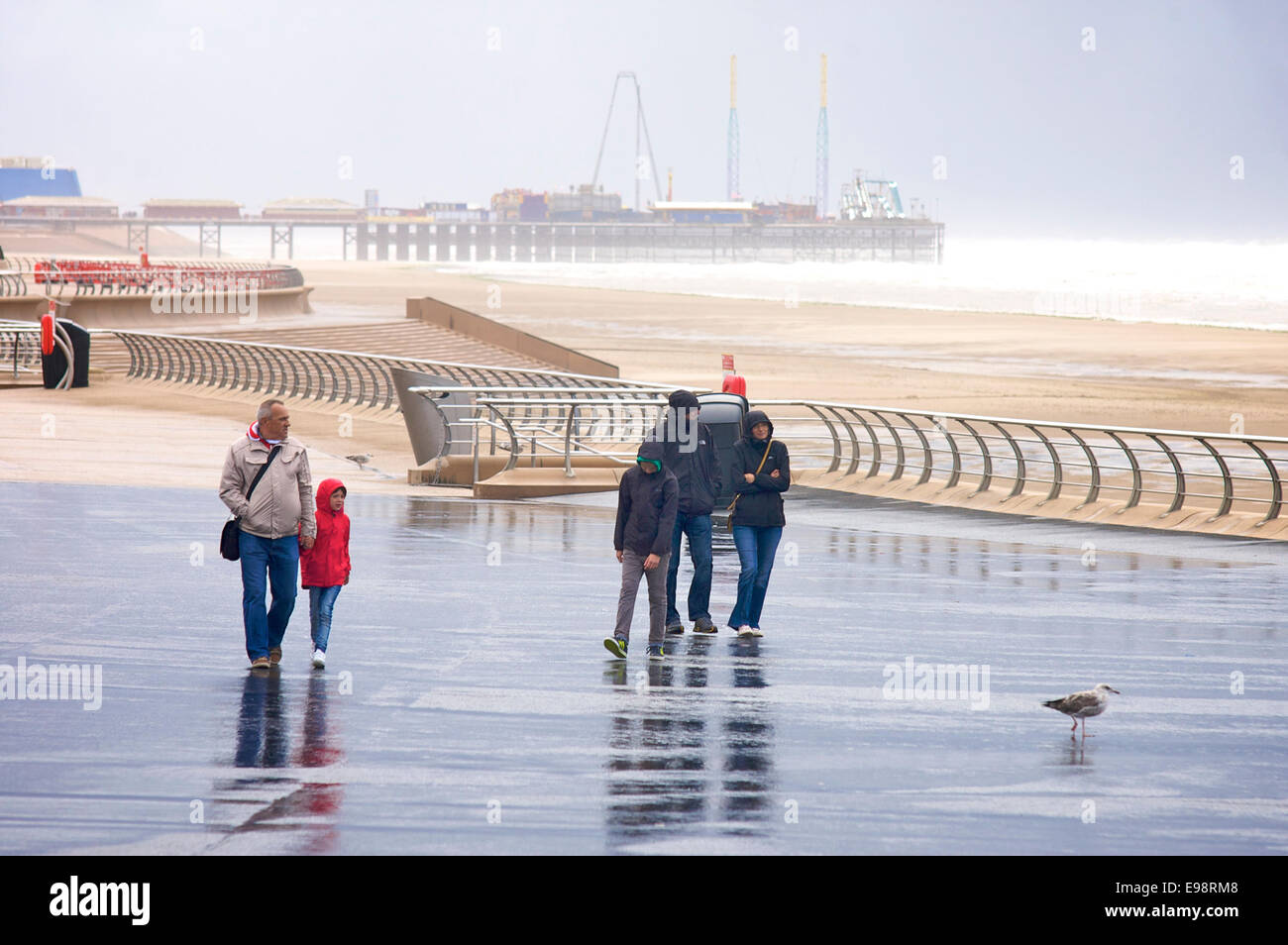 Group of people walking along the seafront in the rain,Blackpool,Lancashire,UK Stock Photo