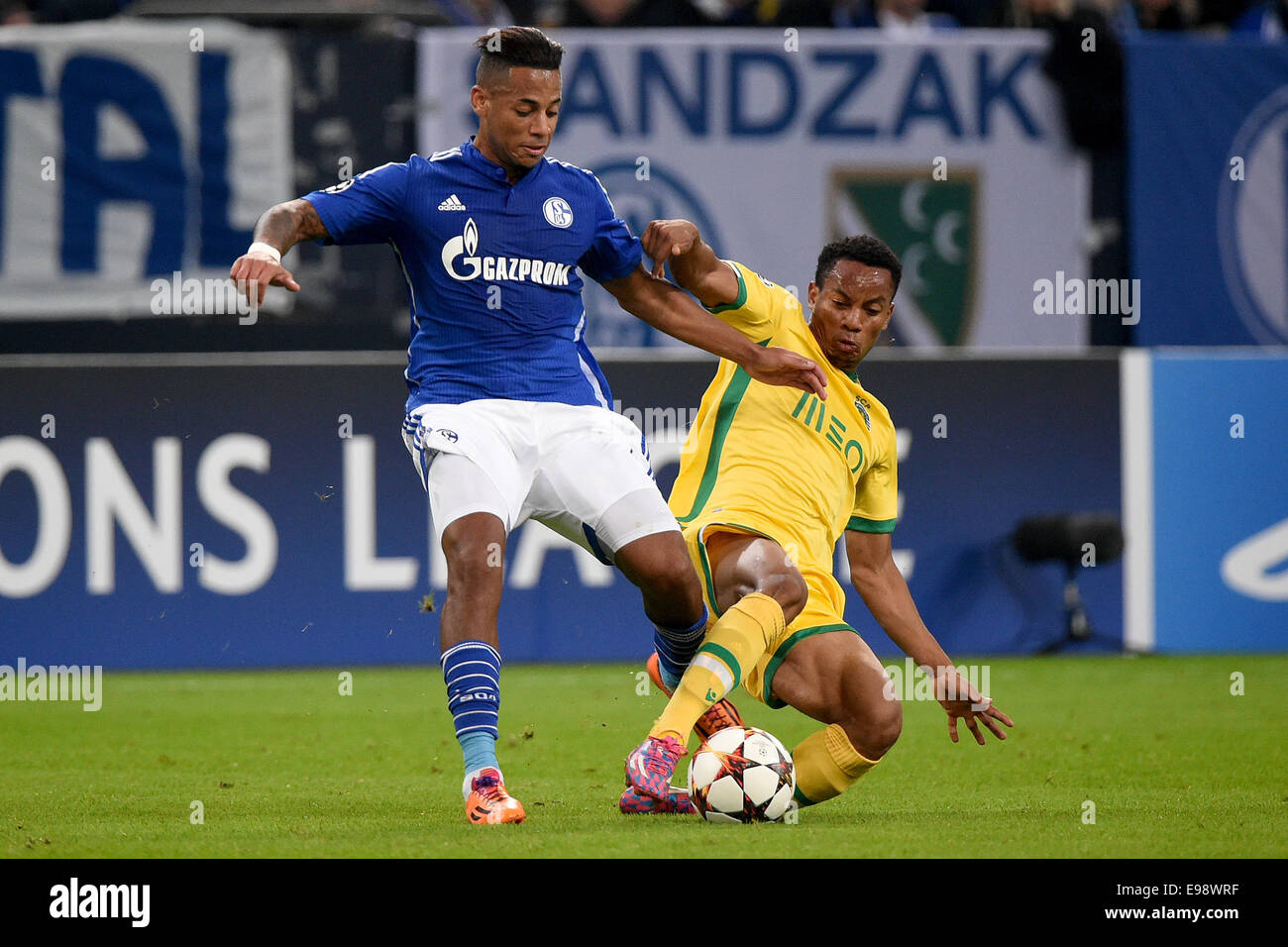 Gelsenkirchen, Germany. 21st Oct, 2014. Schalke's Dennis Aogo (l) and Andre Carrillo vie for the ball during the Champions League Group G match between FC Schalke 04 and Sporting Lissabon in Gelsenkirchen, Germany, 21 October 2014. Credit:  dpa picture alliance/Alamy Live News Stock Photo
