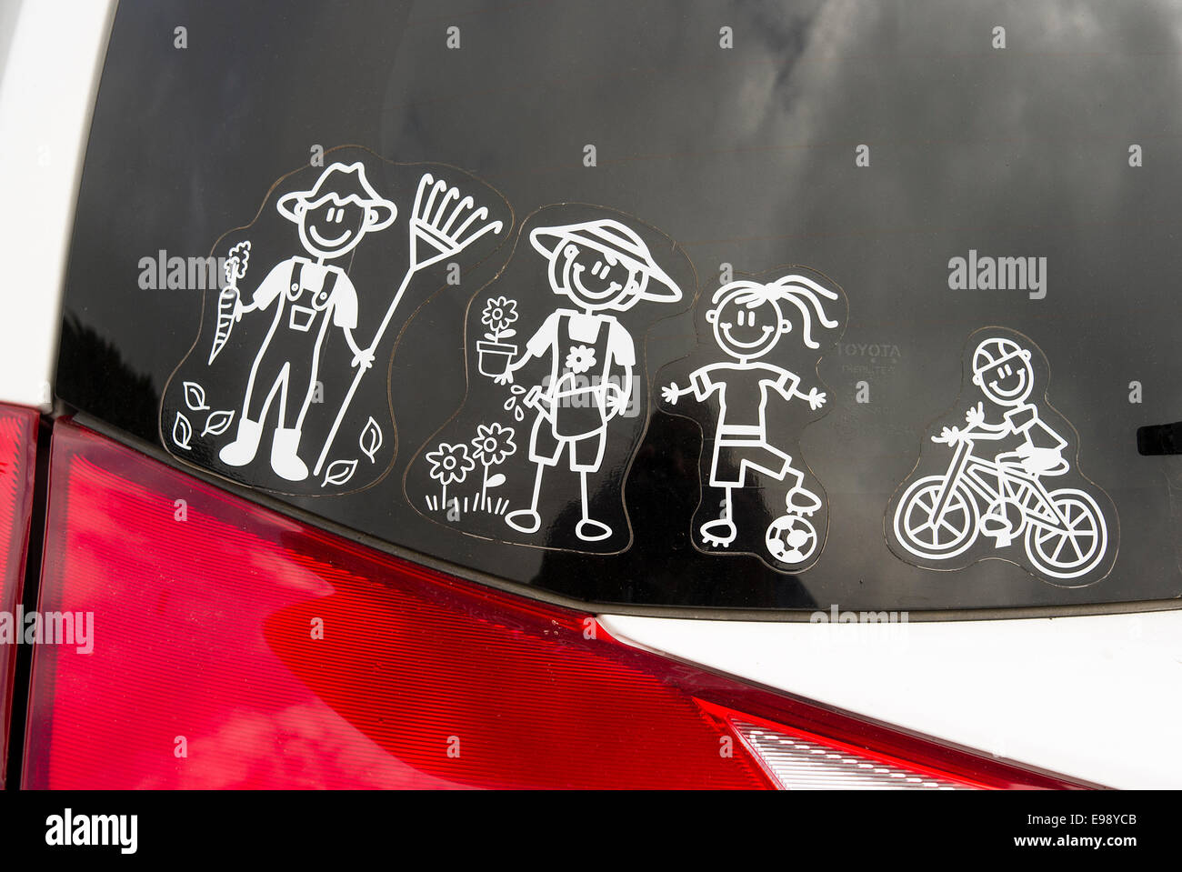 Cartoon characters depicting typical onboard MPV loads. Visible on rear window of vehicle Stock Photo