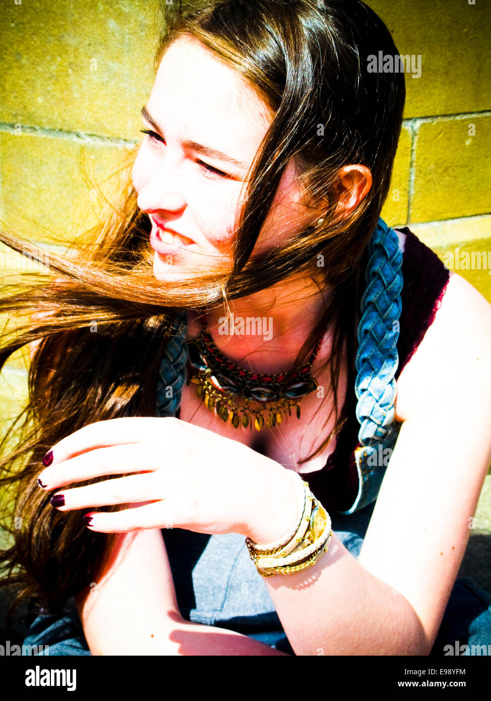Young girl sitting in sun hair blowing in wind Stock Photo - Alamy