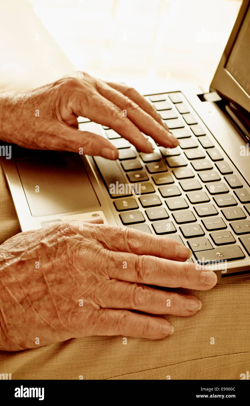 Senior person's hands using a laptop. Stock Photo